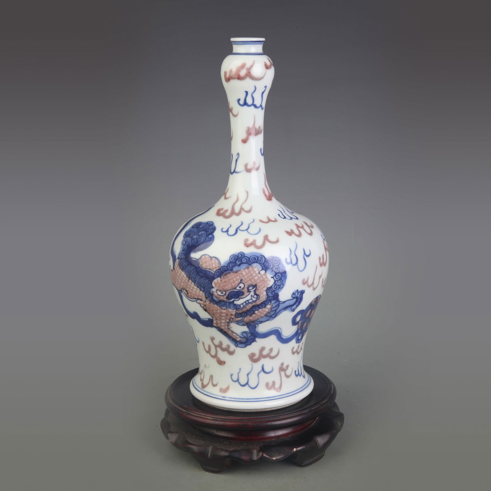 BLUE AND WHITE UNDERGLAZE RED AUSPICIOUS BEAST PATTERN LONG-NECK GARLIC HEAD VASE: Qing Dynasty; Diameter: 3.5 inch; High: 9.9 inch