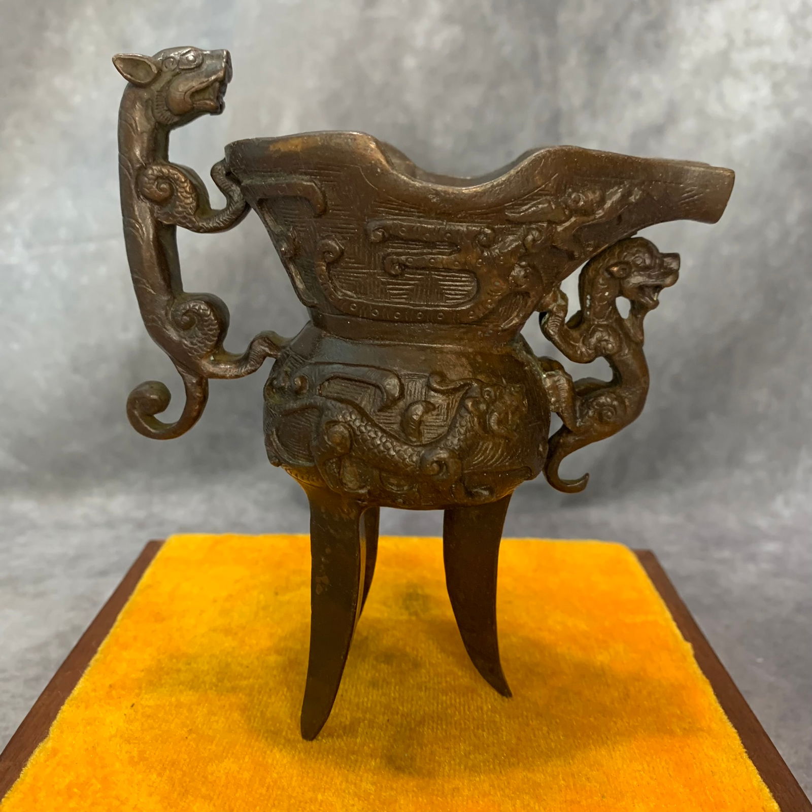 A FINELY CARVED BRONZE THREE FOOT WINE CUP: Qing Dynasty; High: 5.3 inch; Width: 4.4 inch; Long: 2.2 inch;