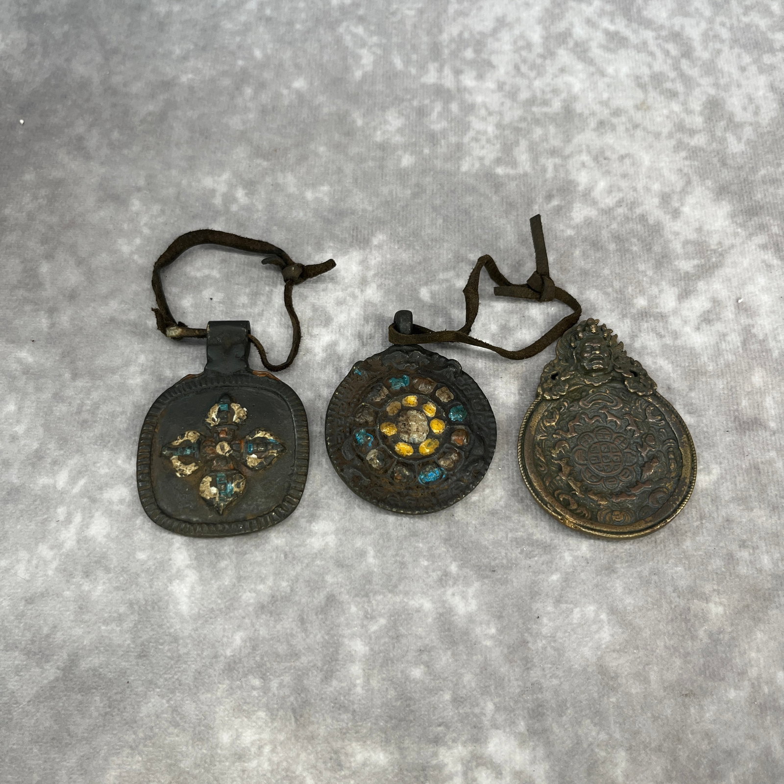 GROUP OF THREE TIBETAN THOGCHAGS RITUAL AMULET PENDANT: Qing Dynasty; Long: 2.3 inch; Width: 1.73 inch; High: 0.3 inch; Long: 2.45 inch; Width: 1.8 inch; High: 0.3 inch; Long: 2.26 inch; Width: 1.79 inch; High: 0.35 inch;