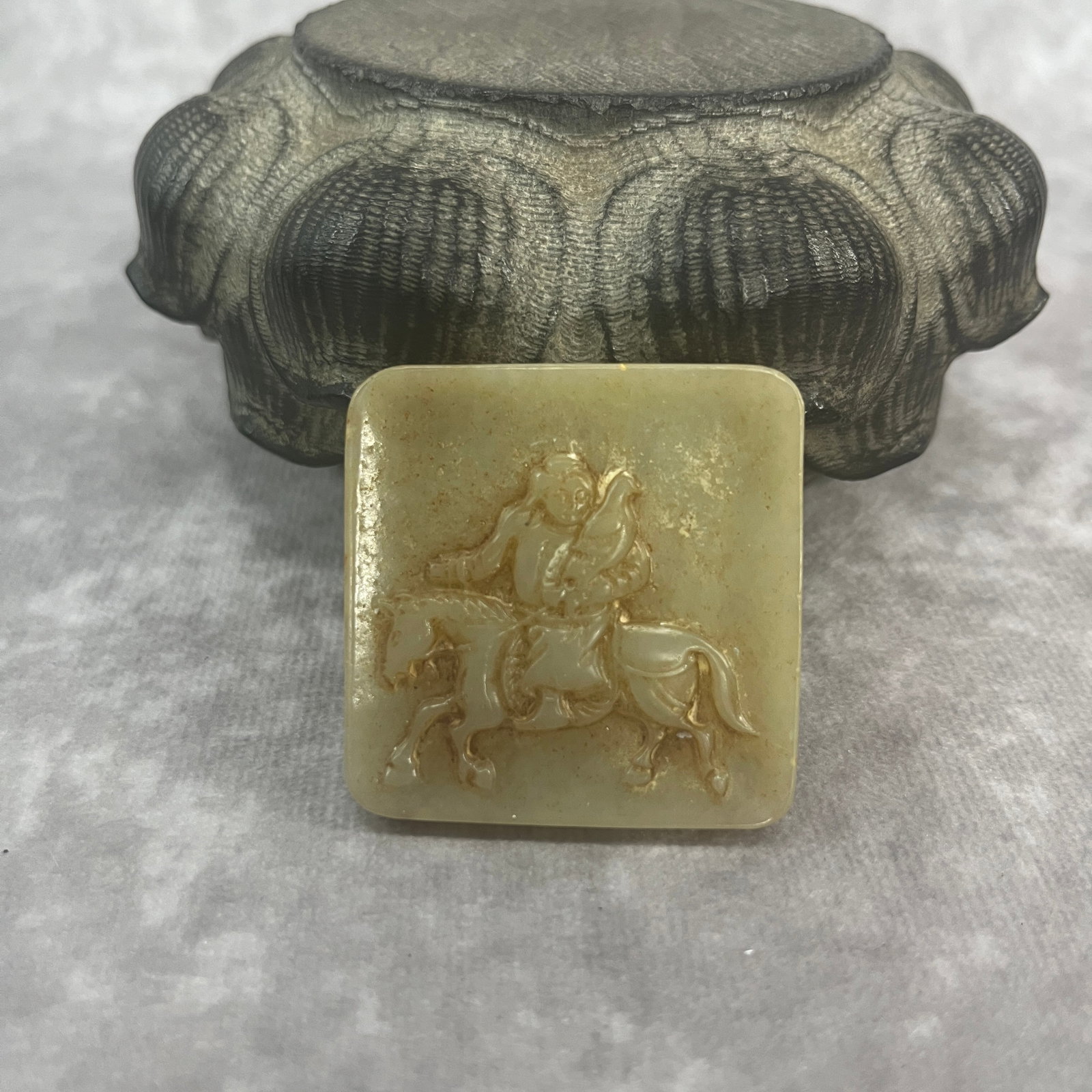 A FINE HETIAN CELADON JADE IN FIGURE OF WARRIOR ON HORSEBACK: Qing Dynasty; Long: 1.68 inch; Width: 1.7 inch; High: 0.21 inch;