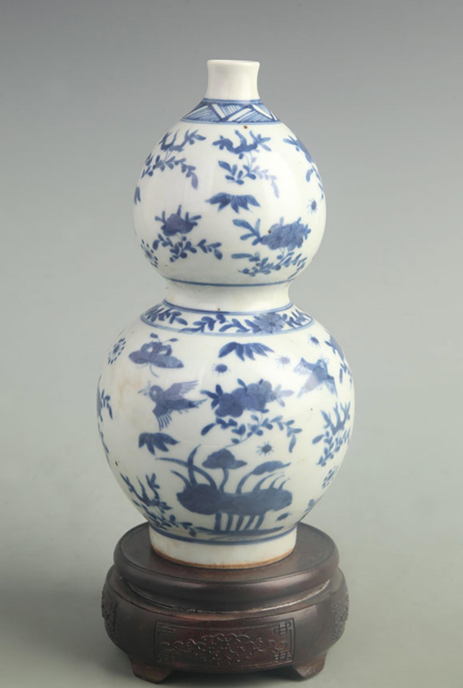 BLUE AND WHITE GOURD-SHAPED VASE WITH FLOWER AND BIRD PATTERNS: Qing Dynasty; High: 9.50 inch; Width: 4.50 inch;