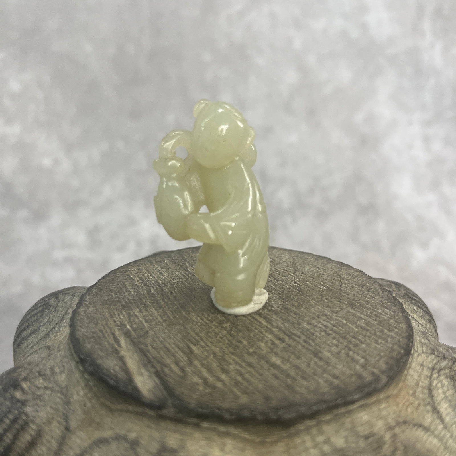A FINE HETIAN CELADON JADE IN FIGURE OF PLAYING BOY: Qing Dynasty; Long: 1.7 inch; Width: 0.92 inch; High: 0.6 inch;