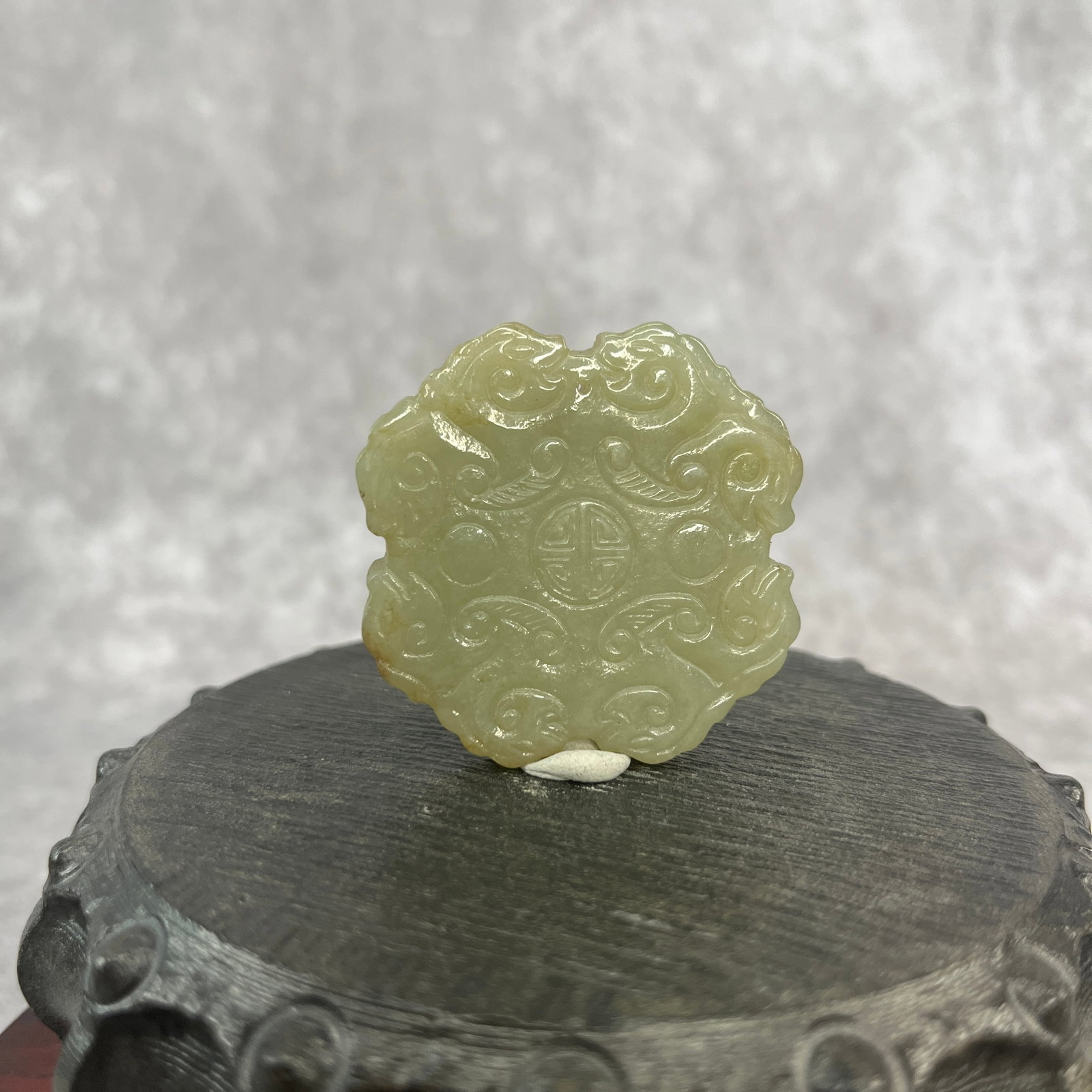 A FINE HETIAN CELADON JADE PENDANT SHOU (LONGEVITY) PATTERN: Qing Dynasty; High: 0.24 inch; Diameter: 1.83 inch;