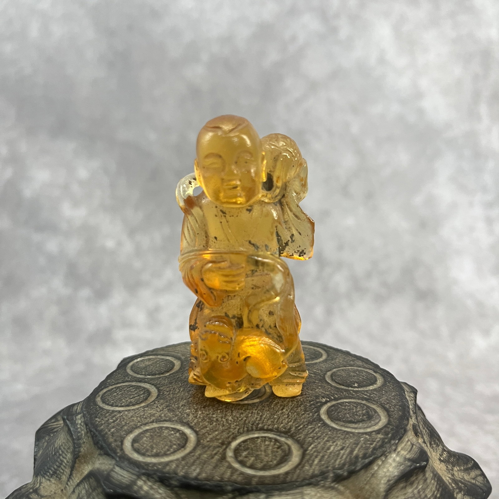 A SMALL AMBER MADE LIU HAI FIGURE (1 of 5)