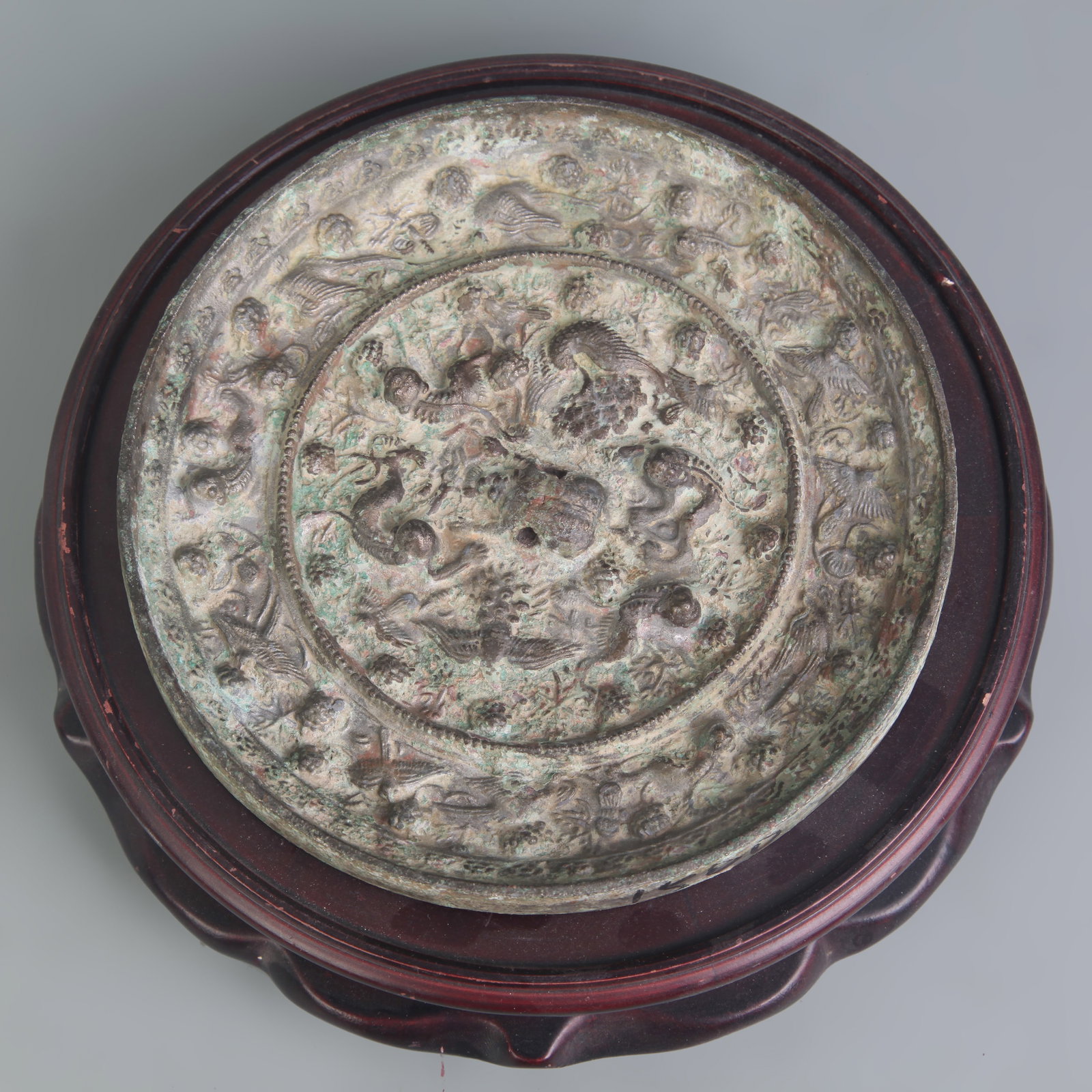 A BRONZE MIRROR WITH SEA BEAST AND GRAPEVINE DECORATION: Diameter: 6.0 inch