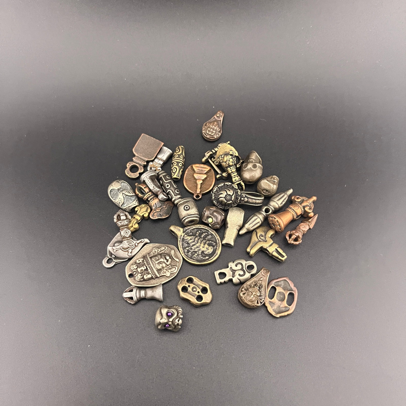 A GROUP OF SMALL TIBETAN BUDDHIST PENDANTS: Long: 0.4 inch to 1.4 inch; Diameter: 0.38 inch to 0.25 inch;