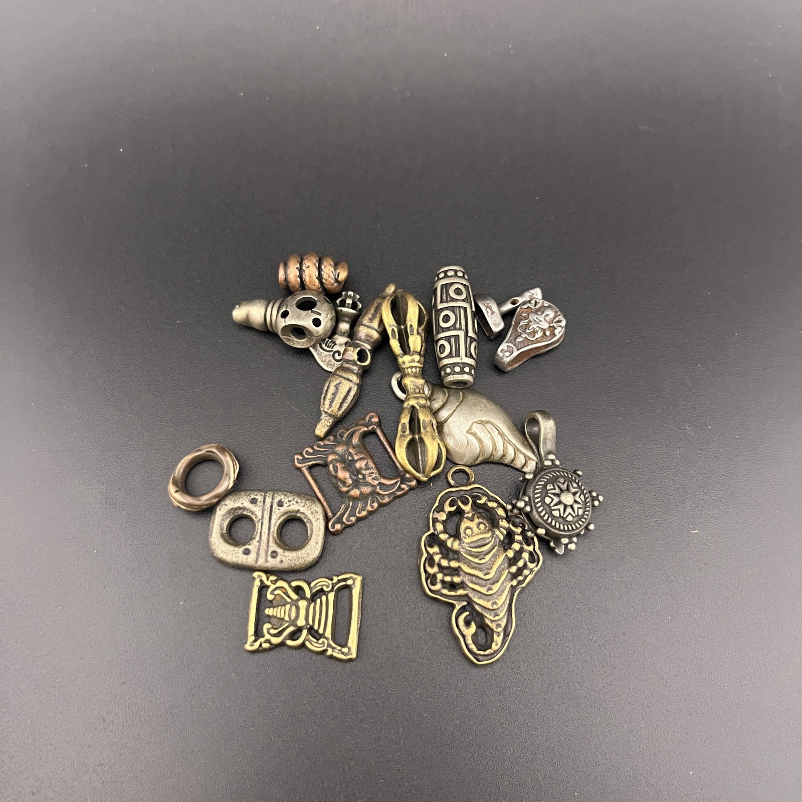 A GROUP OF SMALL TIBETAN BUDDHIST PENDANTS: Long: 0.6 inch to 1.6 inch; Diameter: 0.36 inch to 0.44 inch;