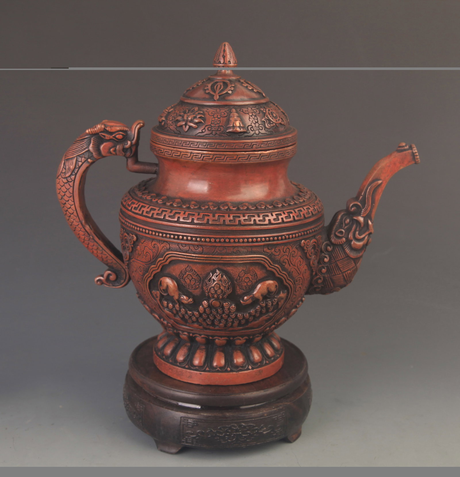 A TIBETAN BUDDHIST BRONZE EWER WITH DRAGON HANDLE AND EIGHT AUSPICIOUS SYMBOLS: 19th Century; High: 9.75 inch; Width: 9.5 inch; Diameter: 4.0 inch; Woodbase for picture and display only