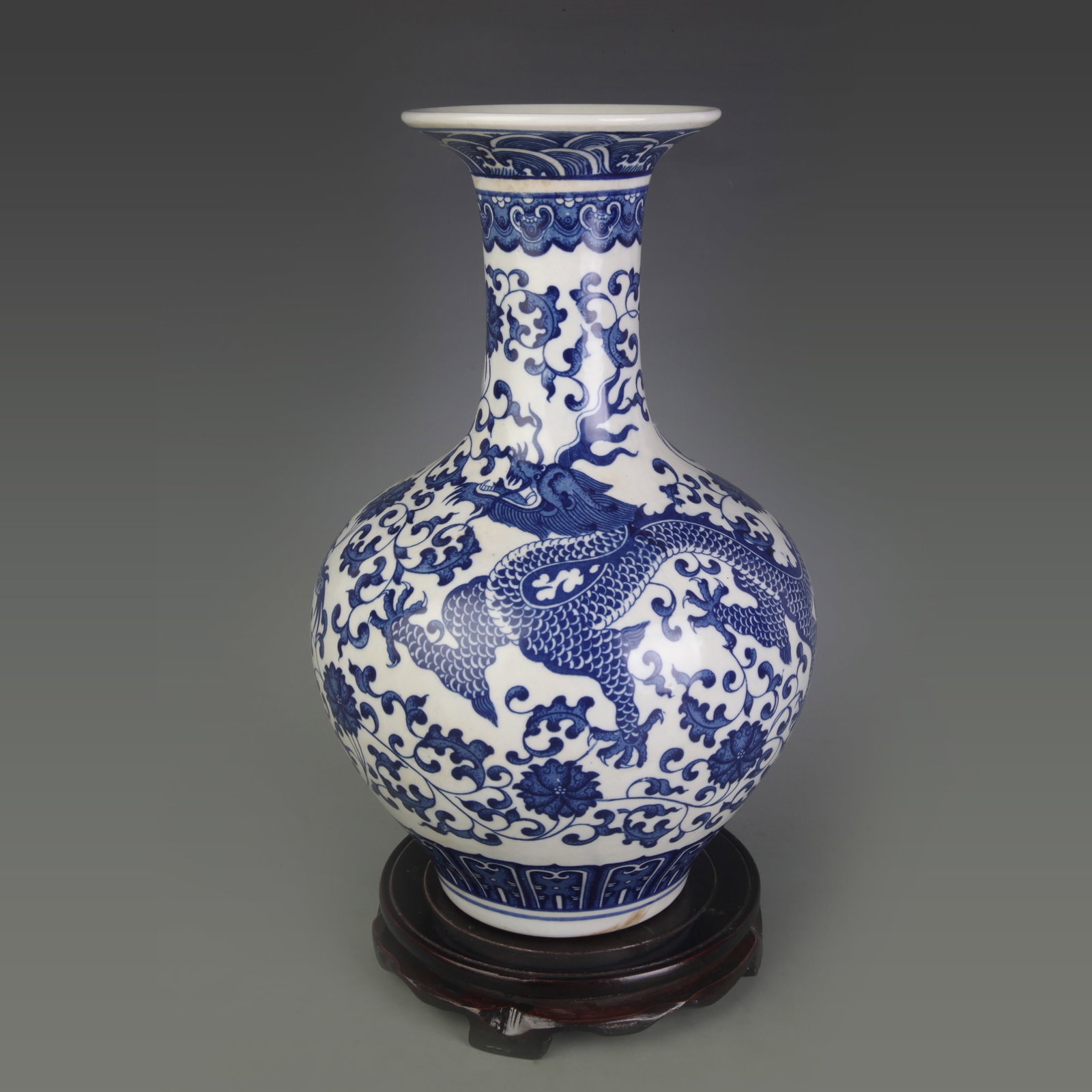 A BLUE AND WHITE FLORAL DRAGON PATTERN PORCELAIN VASE: Qing Dynasty Qian Long Period; Diameter: 5.0 inch; High: 13.2 inch; Woodbase for picture and display only