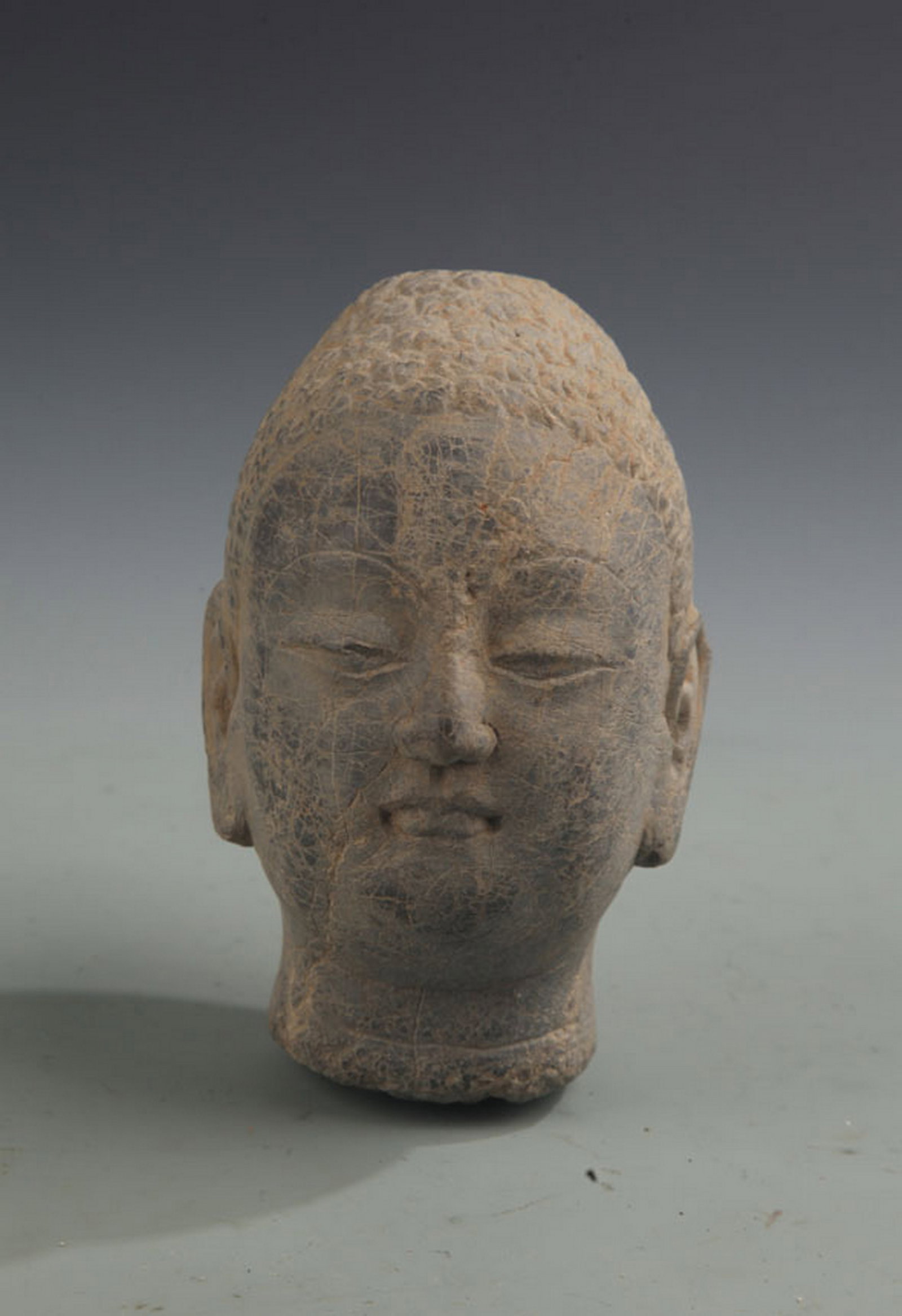 A FINE CARVED STONE BUDDHA HEAD: West Qi Style; High: 5.75 inch; Width: 3.25 inch; Woodbase for picture and display only