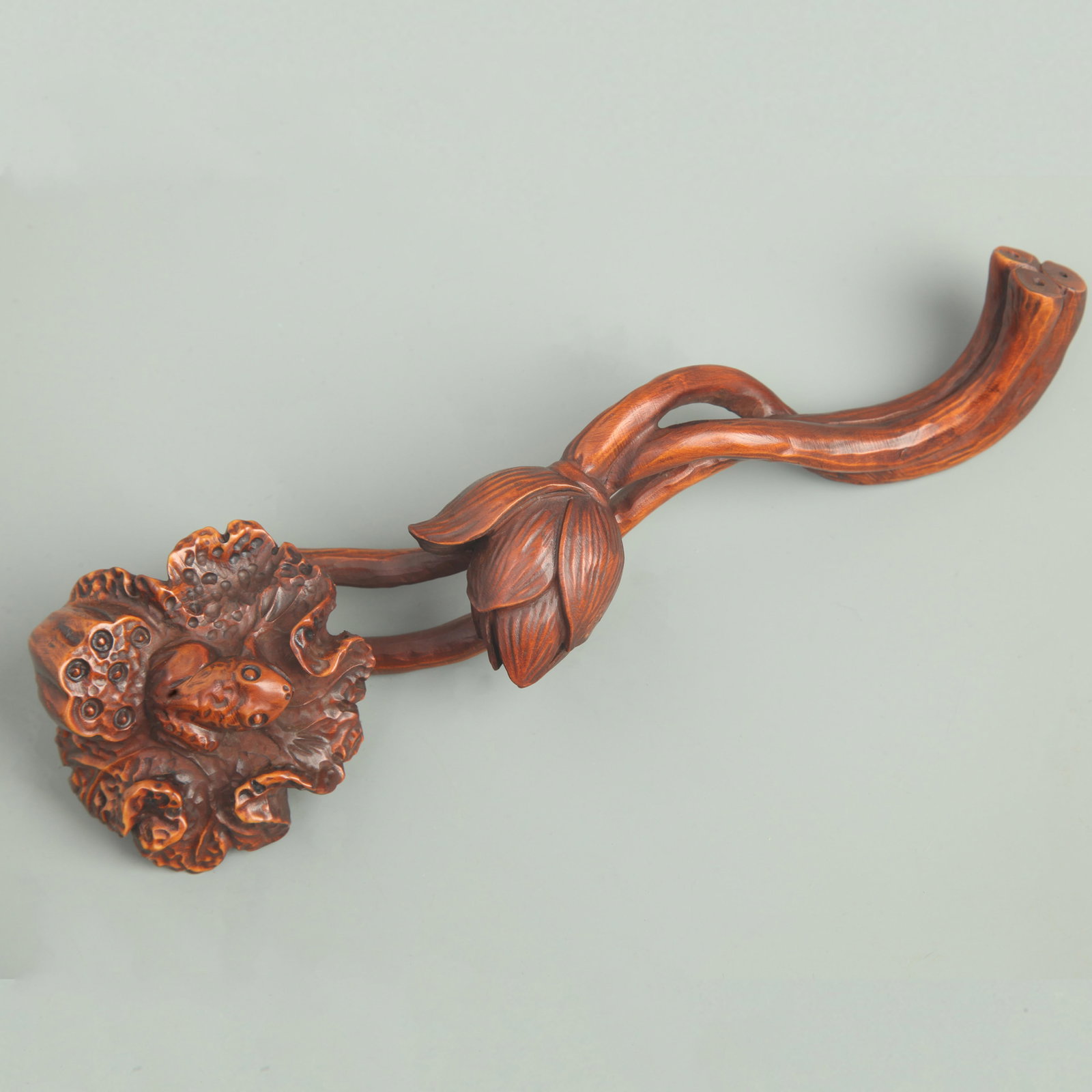 A BOXWOOD CARVED RUYI WITH LOTUS AND FROG MOTIF: Qing Dynasty; Long: 7.7 inch; Width: 2.3 inch; Woodbase for picture and display only