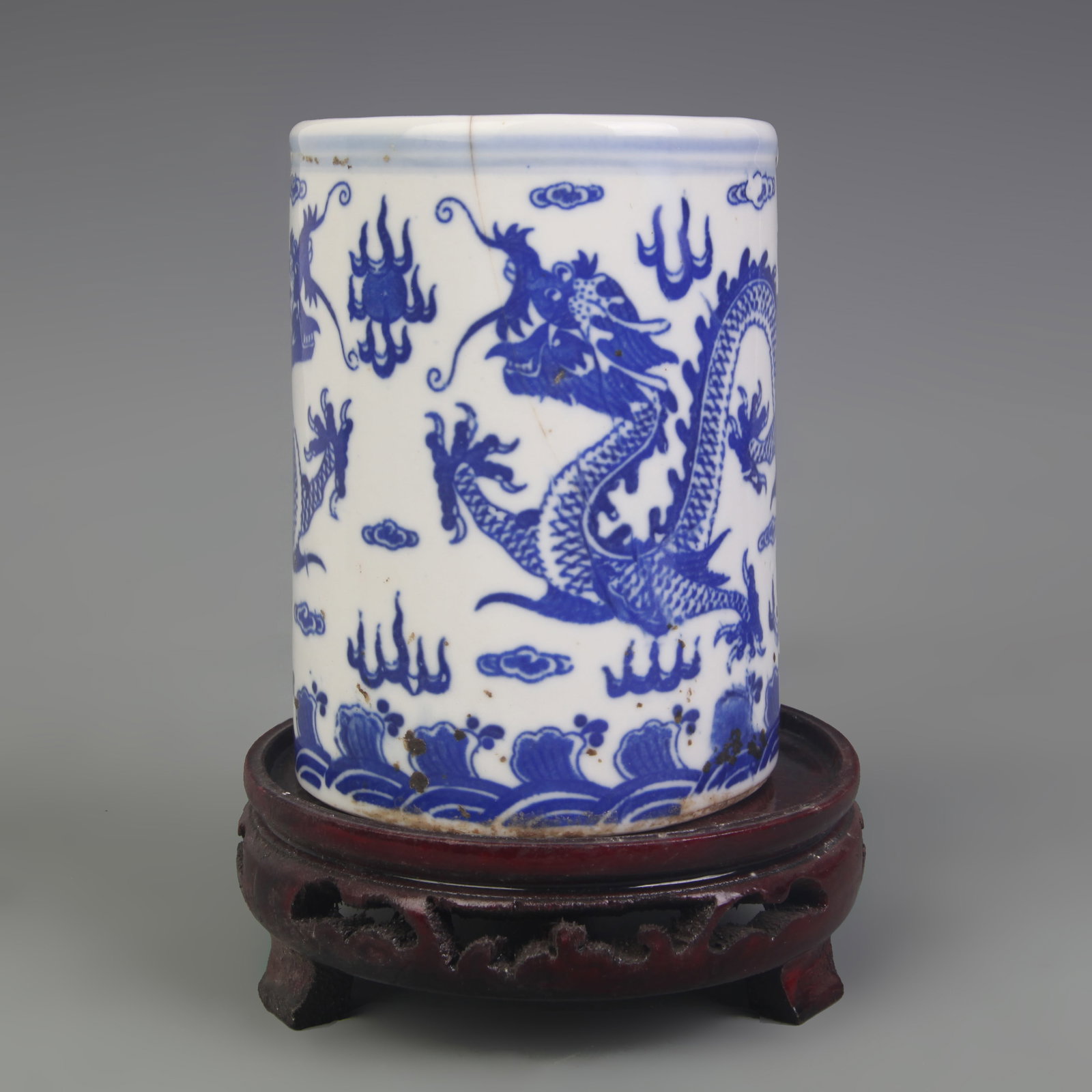 A BLUE-AND-WHITE ‘DRAGON’ PATTERN PORCELAIN BRUSH POT WITH CRACK: Qing Dynasty Qian Long Period; Diameter: 3.5 inch; High: 4.6 inch; Woodbase for picture and display only
