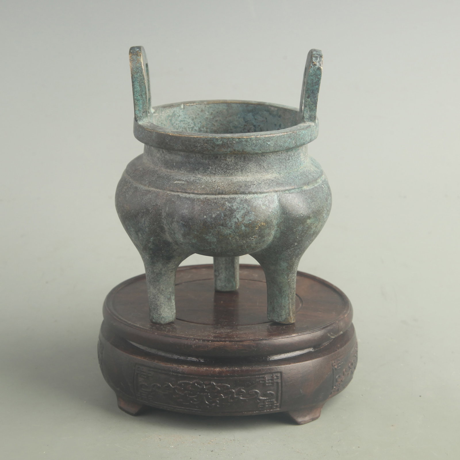 BRONZE TRIPOD CENSER WITH UPRIGHT HANDLES: Qing Dynasty; High: 5.20 inch; Long: 3.80 inch; Woodbase for picture and display only