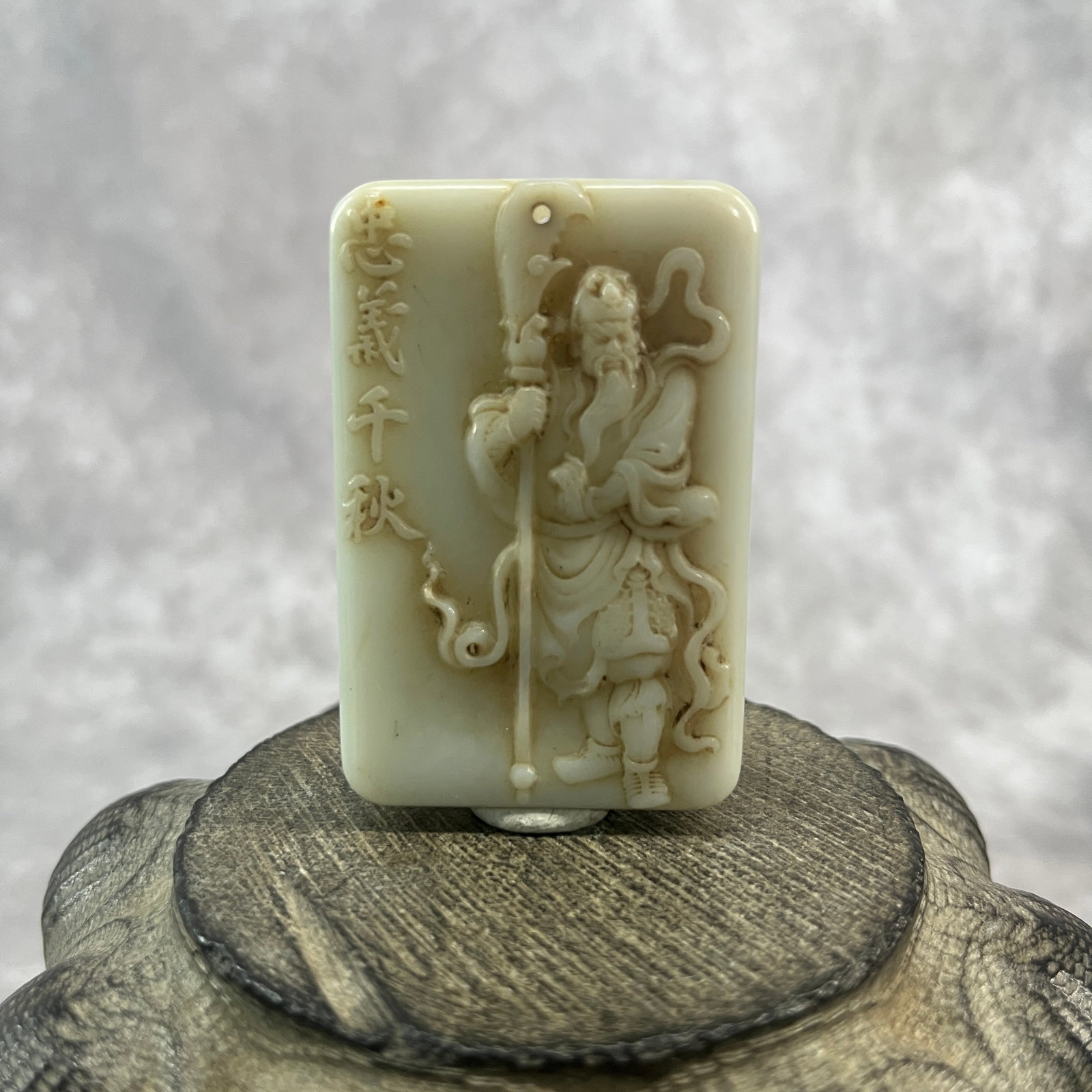 A FINE HETIAN JADE PENDANT WITH GUAN YU: Qing Dynasty; Long: 2.32 inch; Width:1.53 inch; Heigh: 0.41 inch; Woodbase for picture and display only