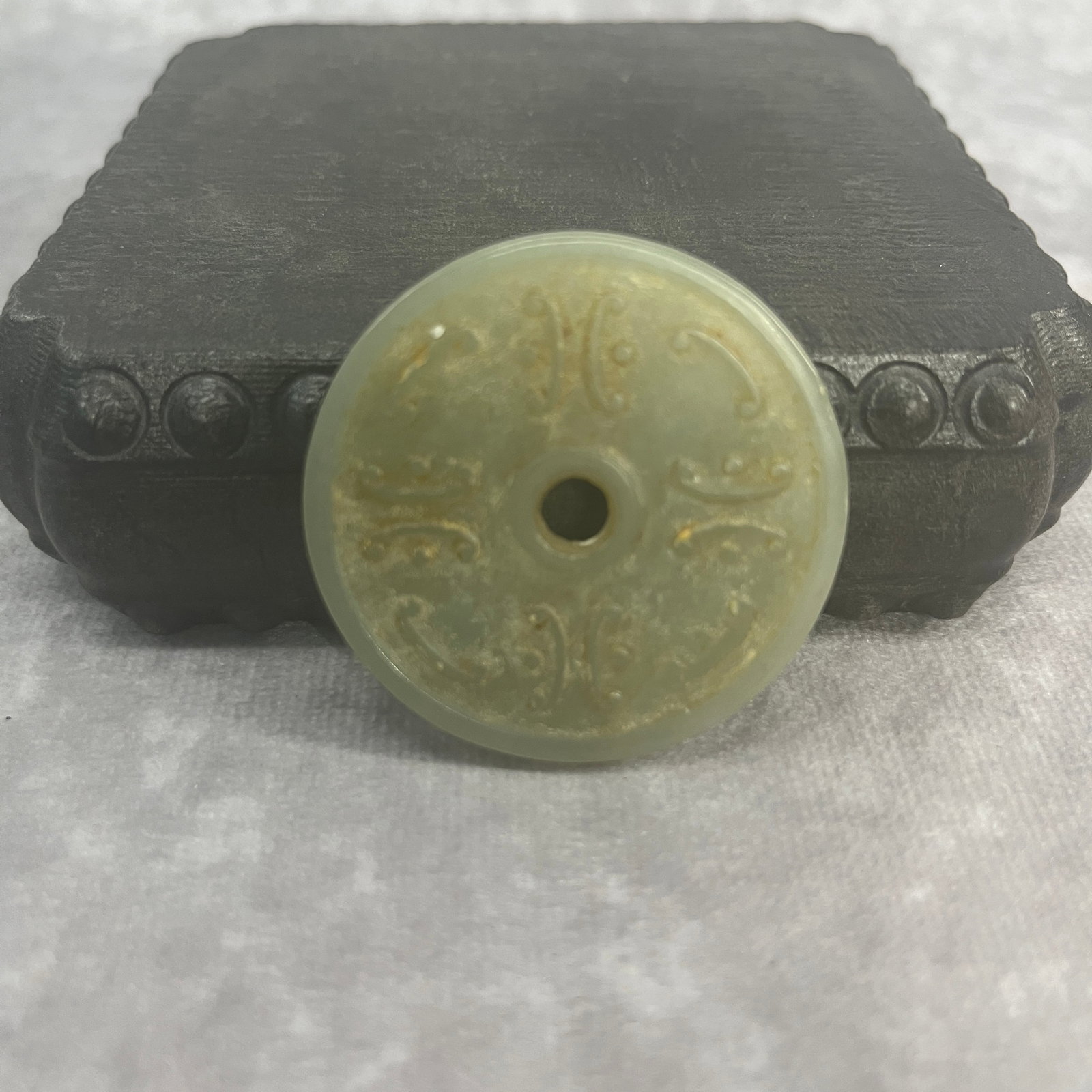 A FINE HETIAN HAND CARVED JADE BI DISC IN FIGURE OF BEAST PATTERN: Qing Dynasty; High: 0.19 inch; Diameter: 1.81 inch; Woodbase for picture and display only