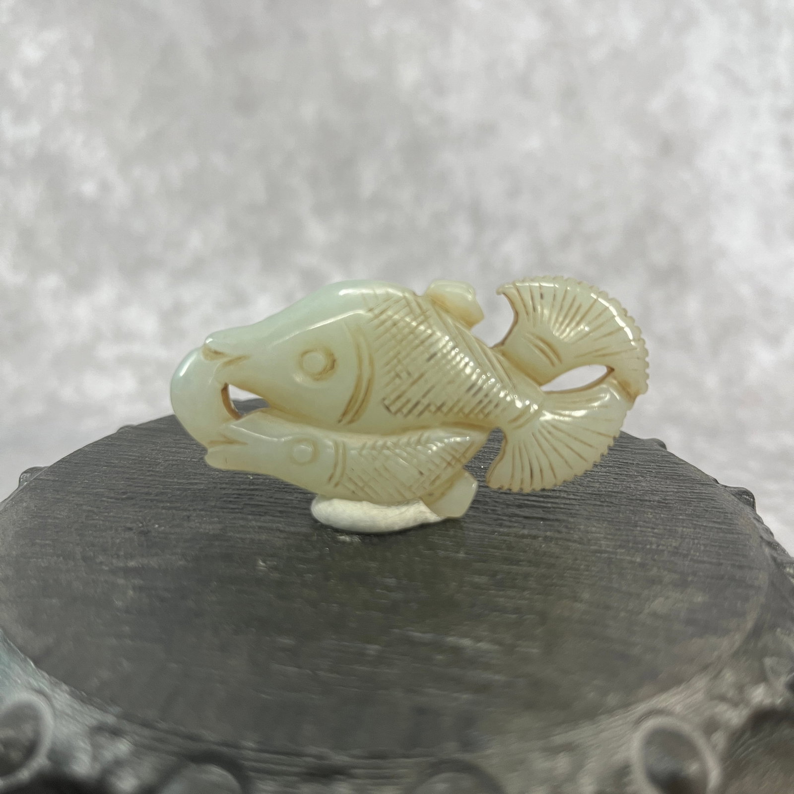 A FINE HETIAN JADE IN FIGURE OF FISH: Qing Dynasty; Long: 2.27 inch; Width: 1.17 inch; High: 0.27 inch; Woodbase for picture and display only