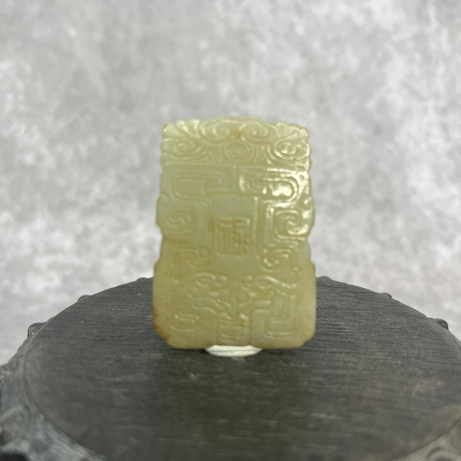 CHINESE CARVED CELADON JADE PENDANT WITH TAOTIE MOTIF: Qing Dynasty; Long: 1.88 inch; Width: 1.32 inch; High: 0.16 inch; Woodbase for picture and display only