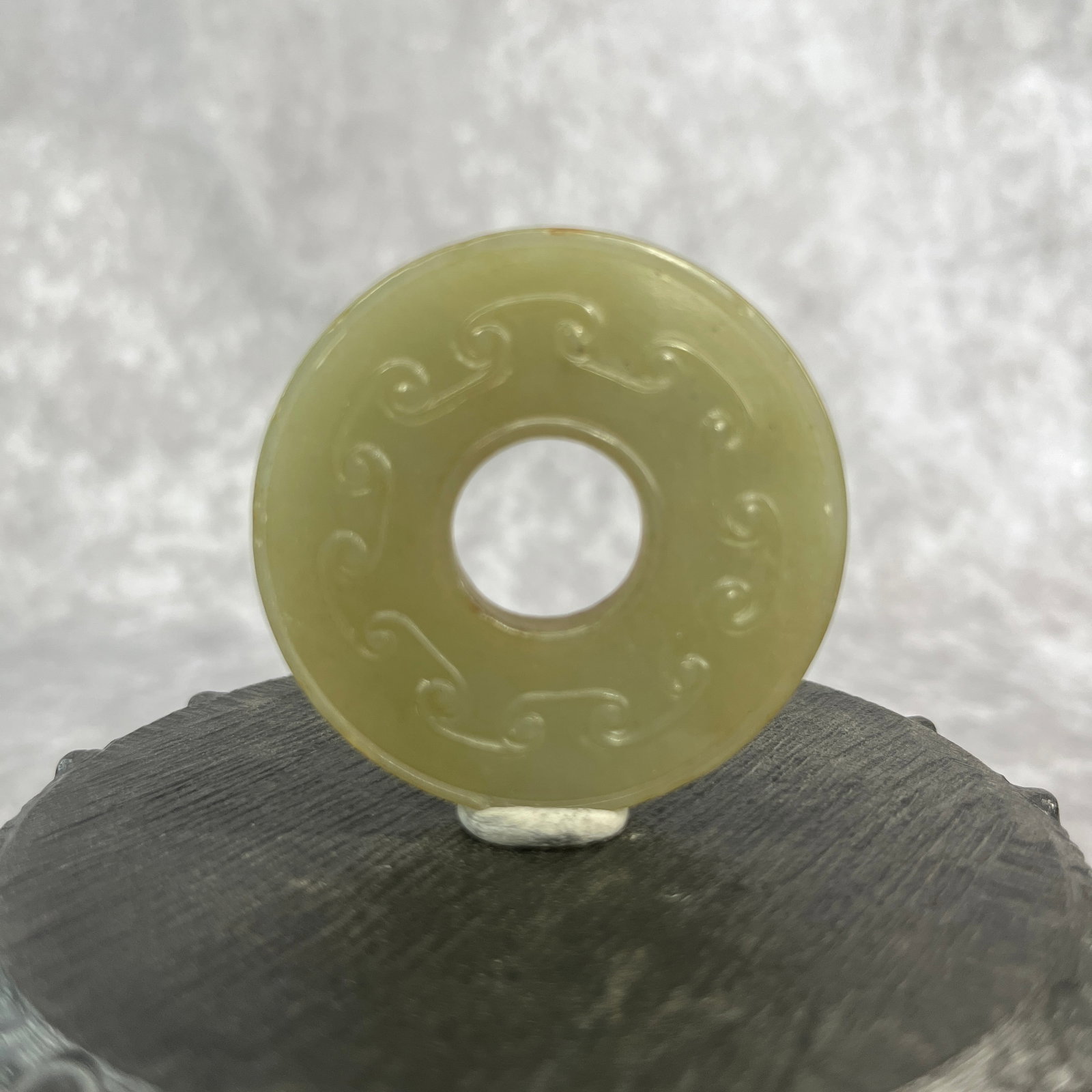 A FINE CLOUD PATTERN JADE BI DISC: Qing Dynasty; Heigh: 0.22 inch; Diameter: 2 inch; Woodbase for picture and display only