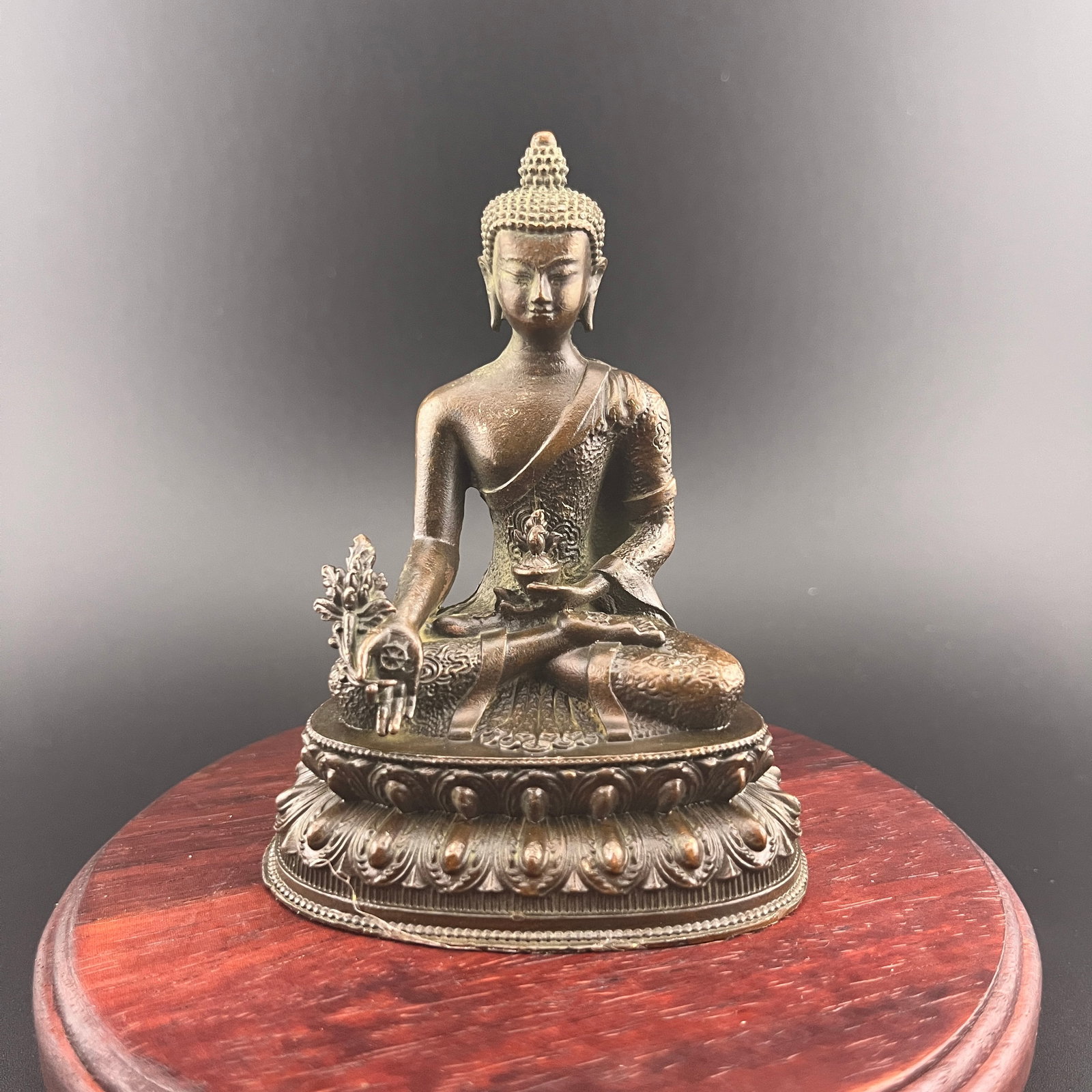 A SMALL BRONZE FIGURE OF MEDICINE BUDDHA (BHAISAJYAGURU): 20th Century; Long: 2.98 inch; Width:2.08 inch; Heigh: 3.9 inch; Woodbase for picture and display only