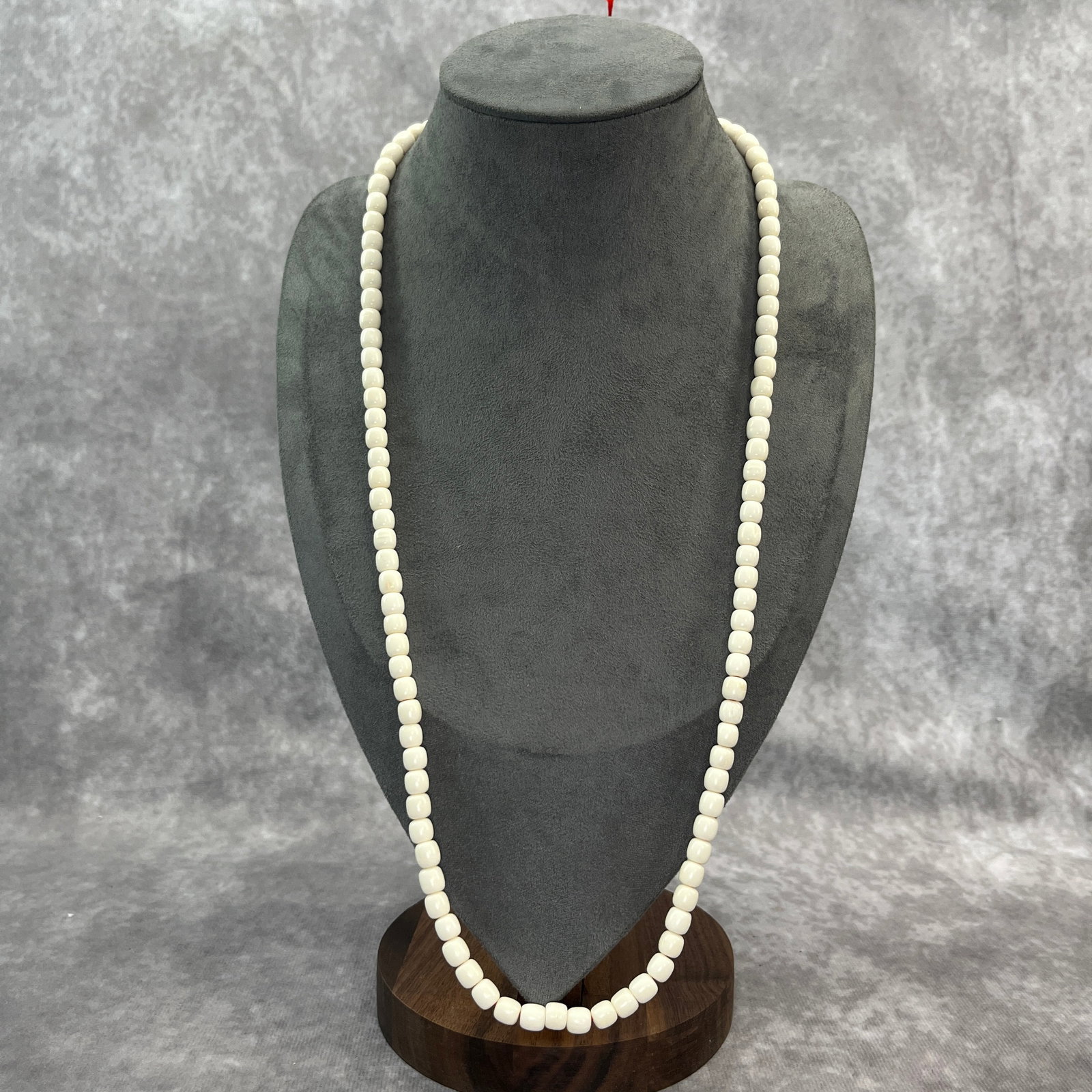 A FINE OX BONE MADE NECKLACE: Modern; Long: 13.6 inch; Diameter: 0.23 inch; Woodbase for picture and display only