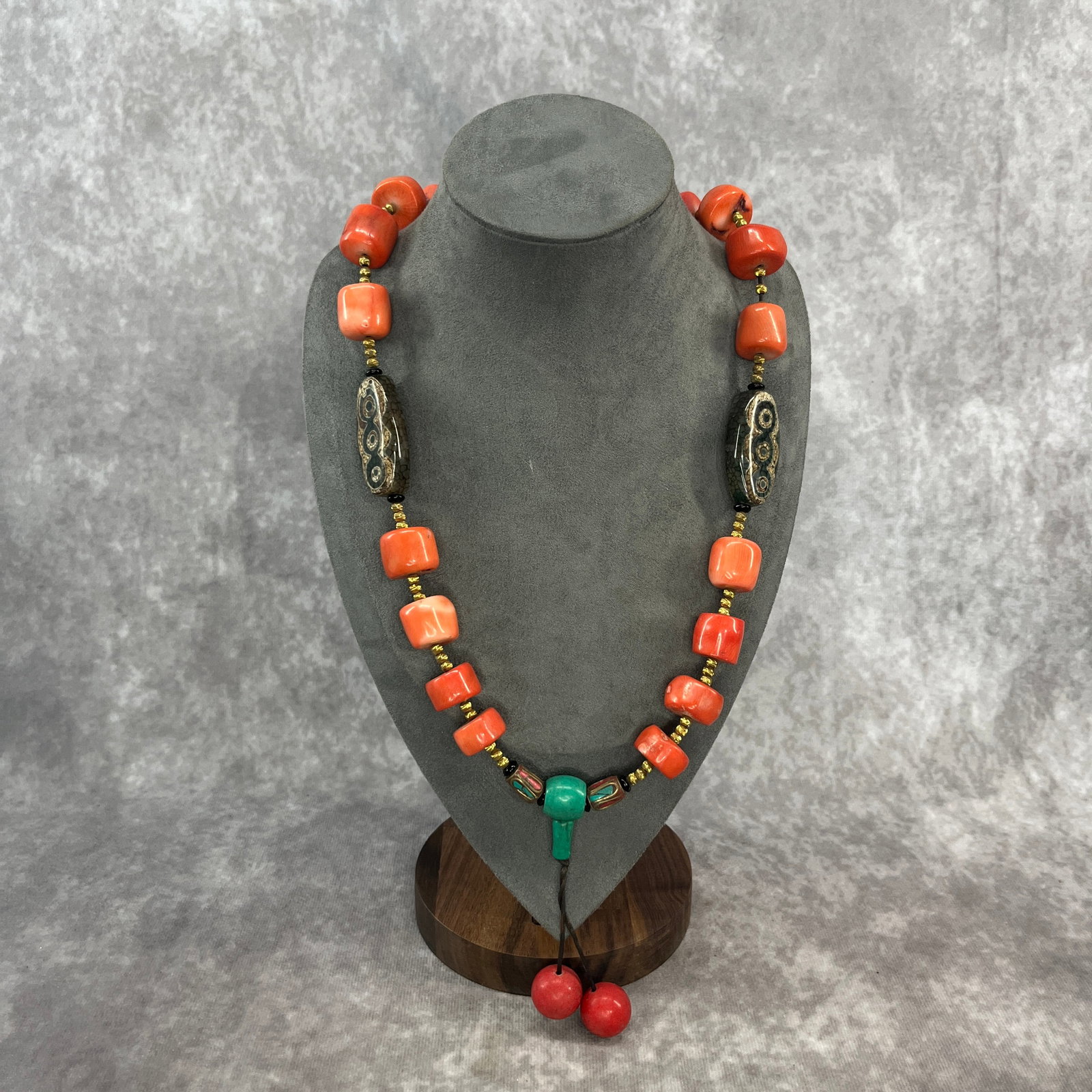 A FINE TIBETIAN STYLE CORAL NECKLACE: Modern; Long: 15.2 inch; Diameter: 0.9 inch; Woodbase for picture and display only