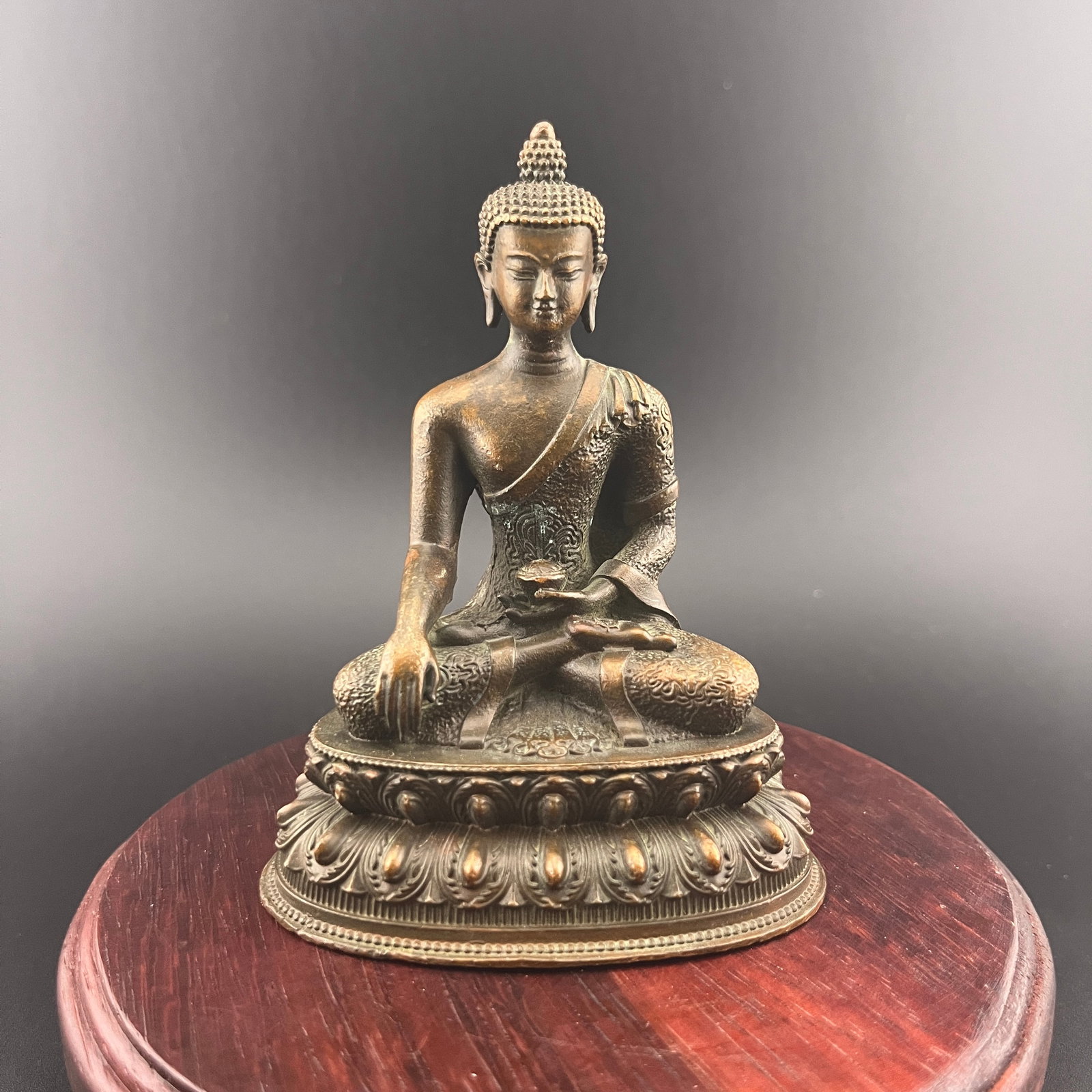 A SMALL BRONZE SHAKYAMUNI BUDDHA: 19th Century; Long: 3 inch; Width:2.2 inch; Heigh: 3.9 inch; Woodbase for picture and display only
