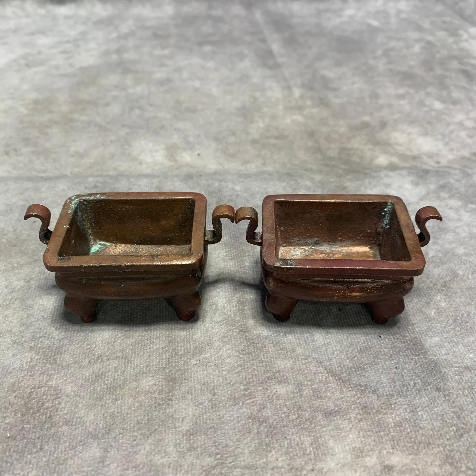 A PAIR OF BRONZE FOUR-LEGGED RUYI-HANDLED CENSERS: Qing Dynasty; Long: 2.8 inch; Width: 1.6 inch; H; 1.3 inch; Woodbase for picture and display only