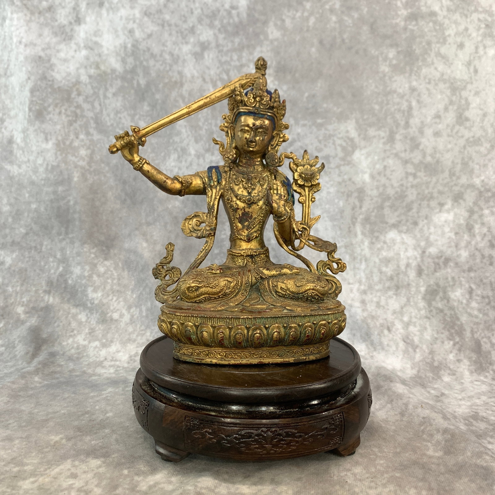 GILT-BRONZE MANJUSHRI WITH FLAMING SWORD: 19th Century; Long: 5.8 inch; Width:3.6 inch; Heigh: 8.5 inch; Woodbase for picture and display only