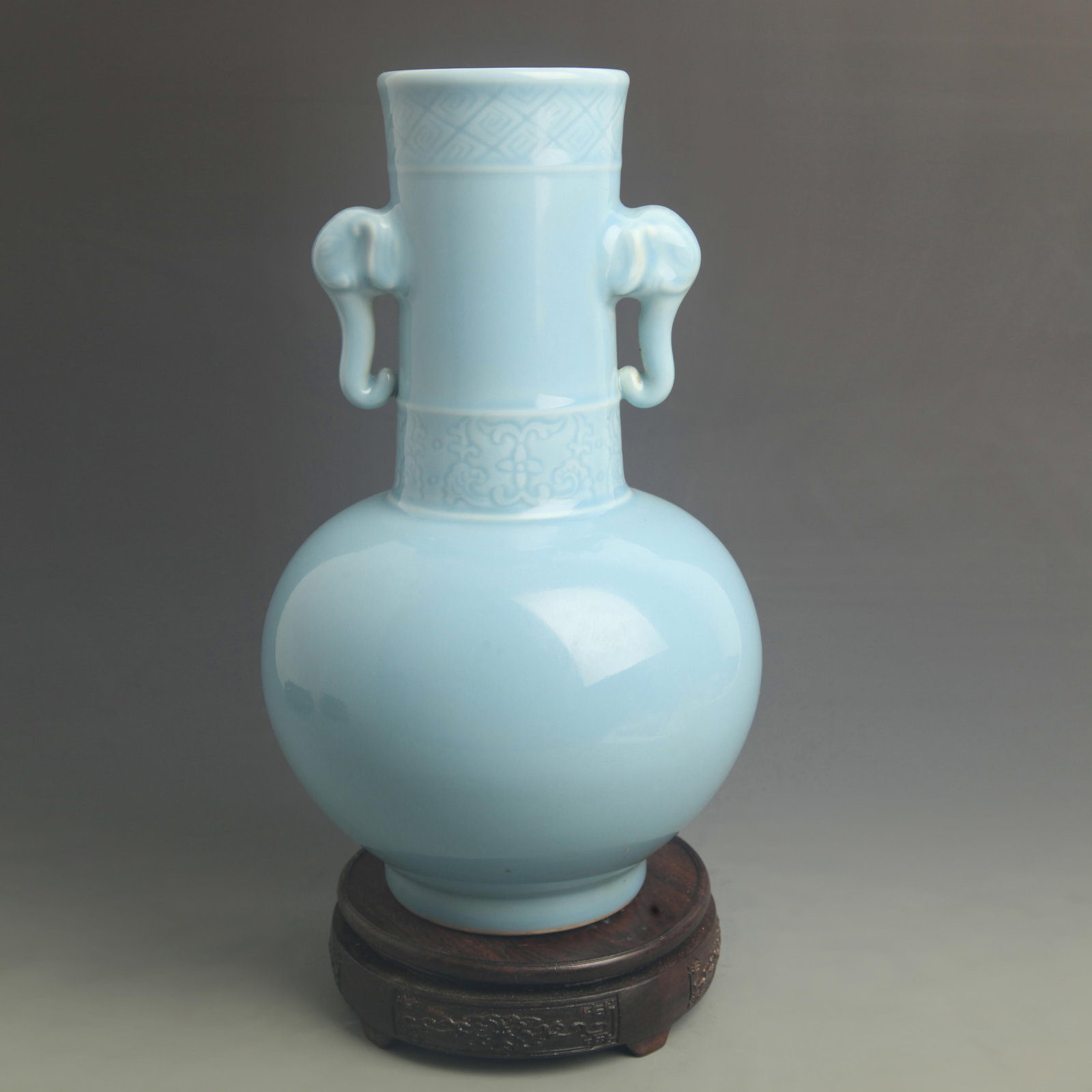 A SKY-BLUE GLAZED ELEPHANT-HEAD HANDLED VASE: Qing Dynasty Qian Long Period; High: 13.3 inch; Diameter: 7.50 inch; Woodbase for picture and display only