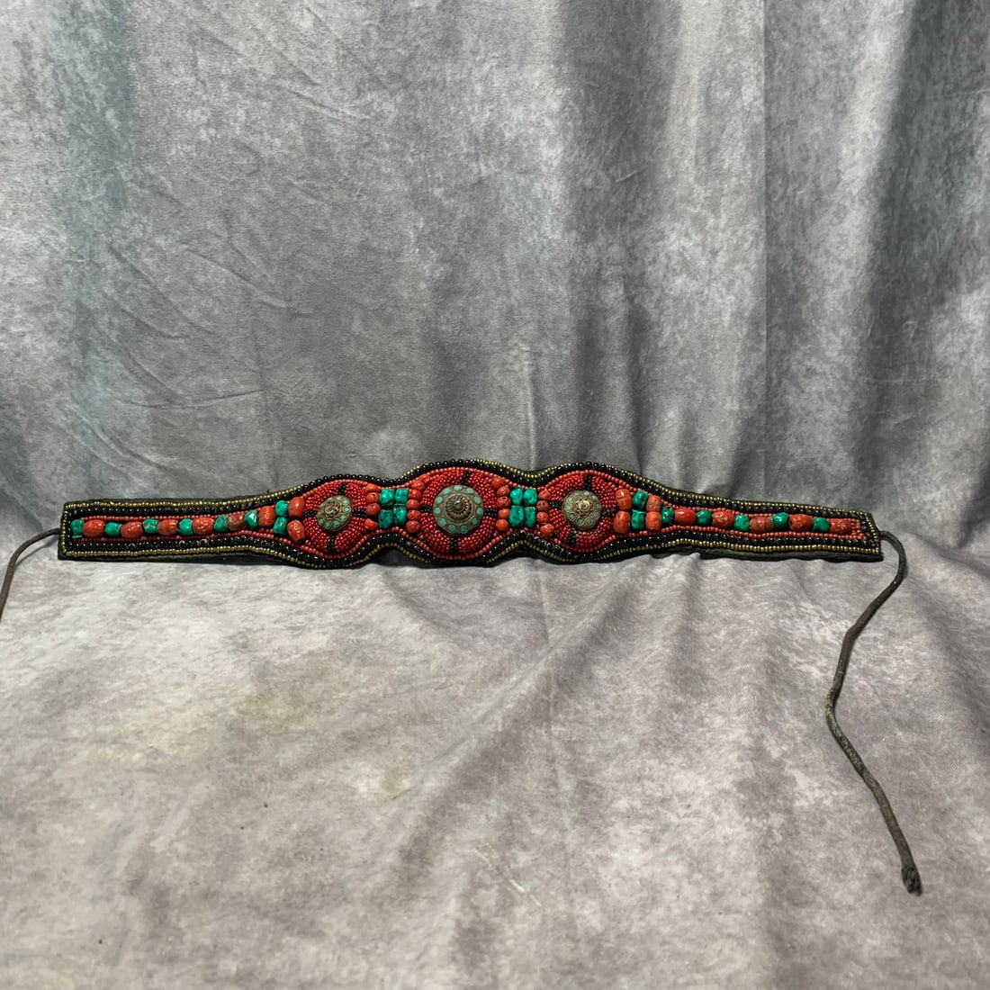 TIBETAN BRONZE INLAID TURQUOISE, CORAL, AND GEMSTONE BELT: Modern; Long: 24.5 inch; Width: 3.5 inch; Woodbase for picture and display only