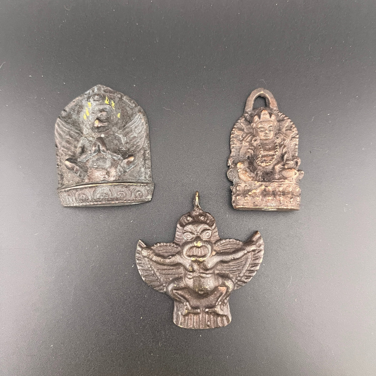 GROUP OF THREE TIBETAN RITUAL AMULET PENDANT: Modern; Long: 2 inch; Width:1.5 inch; Heigh: 0.4 inch; Long: 2.08 inch; Width:1.98 inch; Heigh: 0.38 inch; Long: 2 inch; Width:1.18 inch; Heigh: 0.4 inch; Woodbase for picture and display only