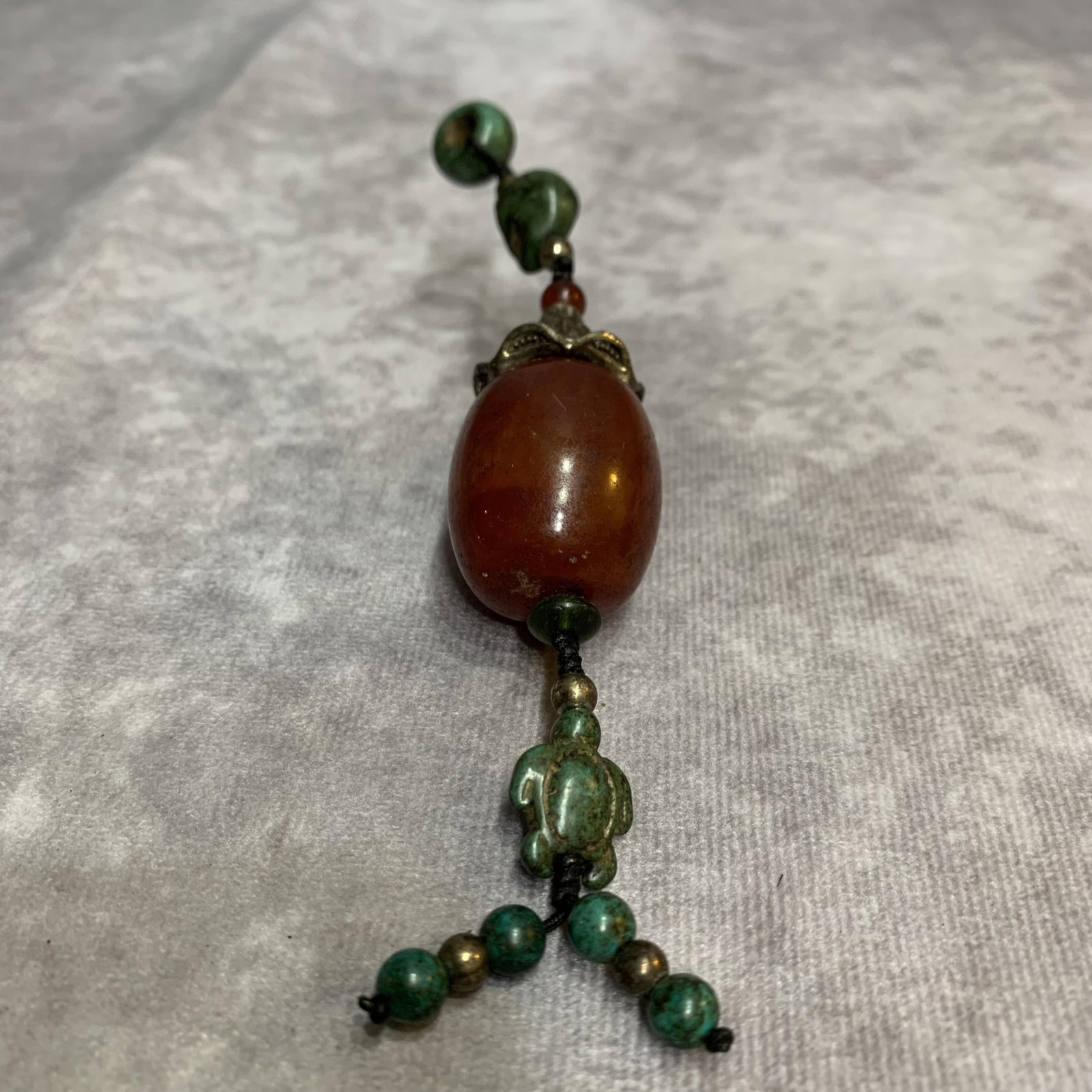 A FINE BEESWAX MADE PENDANT: Modern, Long: 5.0 inch; Diameter: 0.9 inch; Woodbase for picture and display only