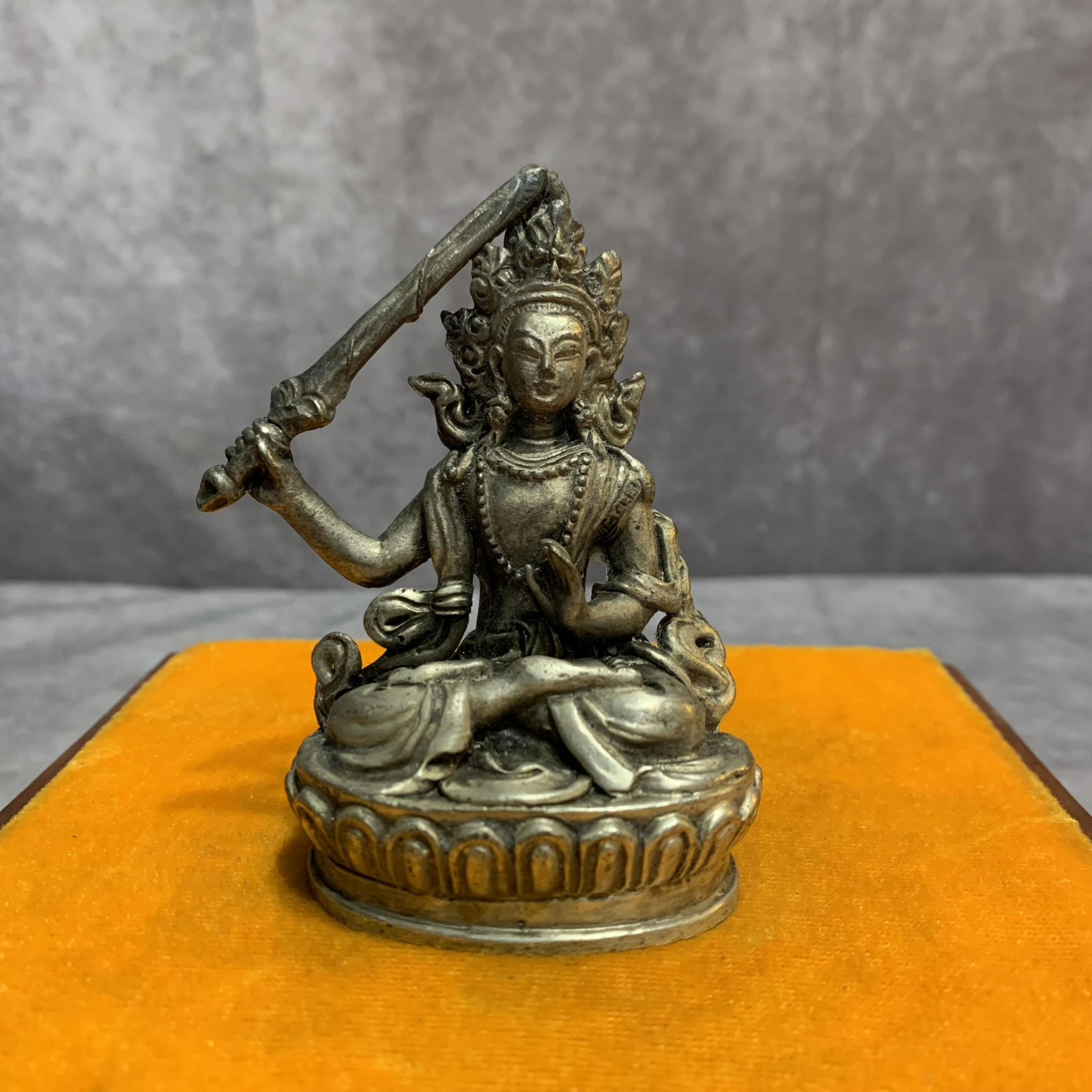 A SMALL WHITE BRONZE MANJUSHRI BUDDHA STATUE: 20th Century, Width: 2.5 inch; High: 3.4 inch; Diameter: 1.3 inch; Woodbase for picture and display only