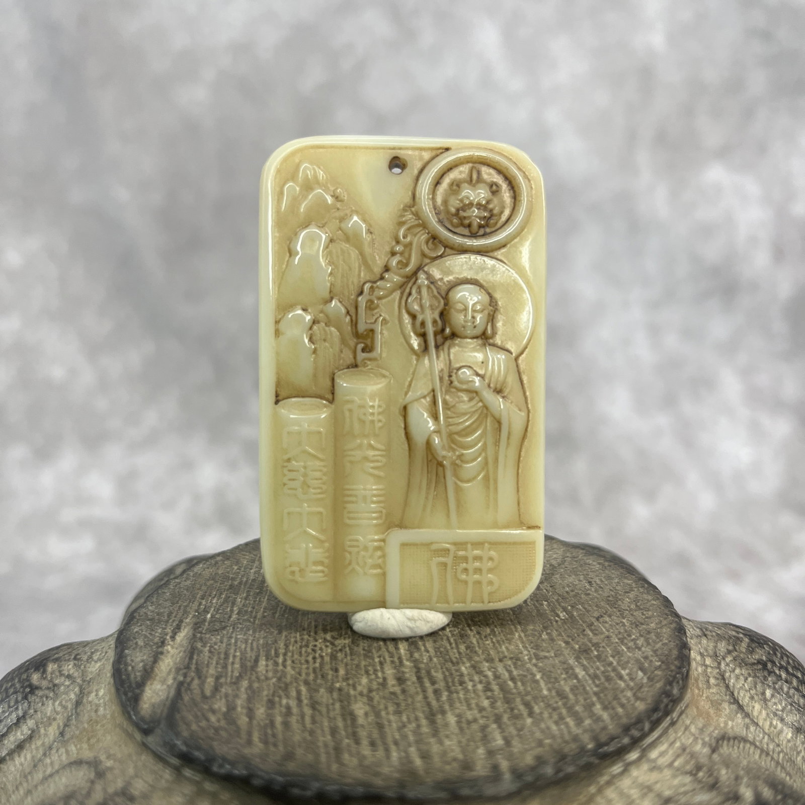 A FINE JADE PENDANT IN FIGURE OF KSITIGARBHA BODHISATTVA: Qing Dynasty; Long: 2.38 inch; Width:1.44 inch; Heigh: 0.29 inch; Woodbase for picture and display only