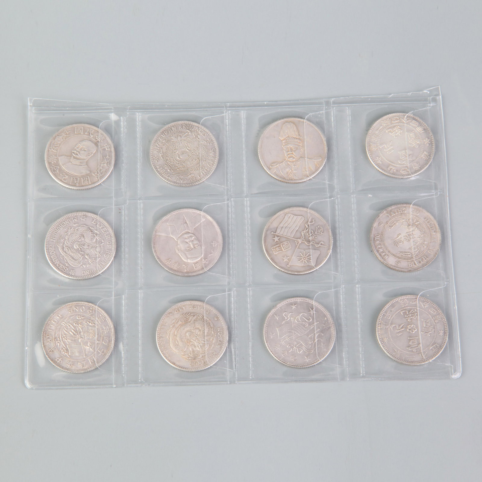 A GROUP OF TWELVE VINTAGE CHINESE COIN: Republic Period; Diameter: 1.0 inch; Wooden base for picture and display only.