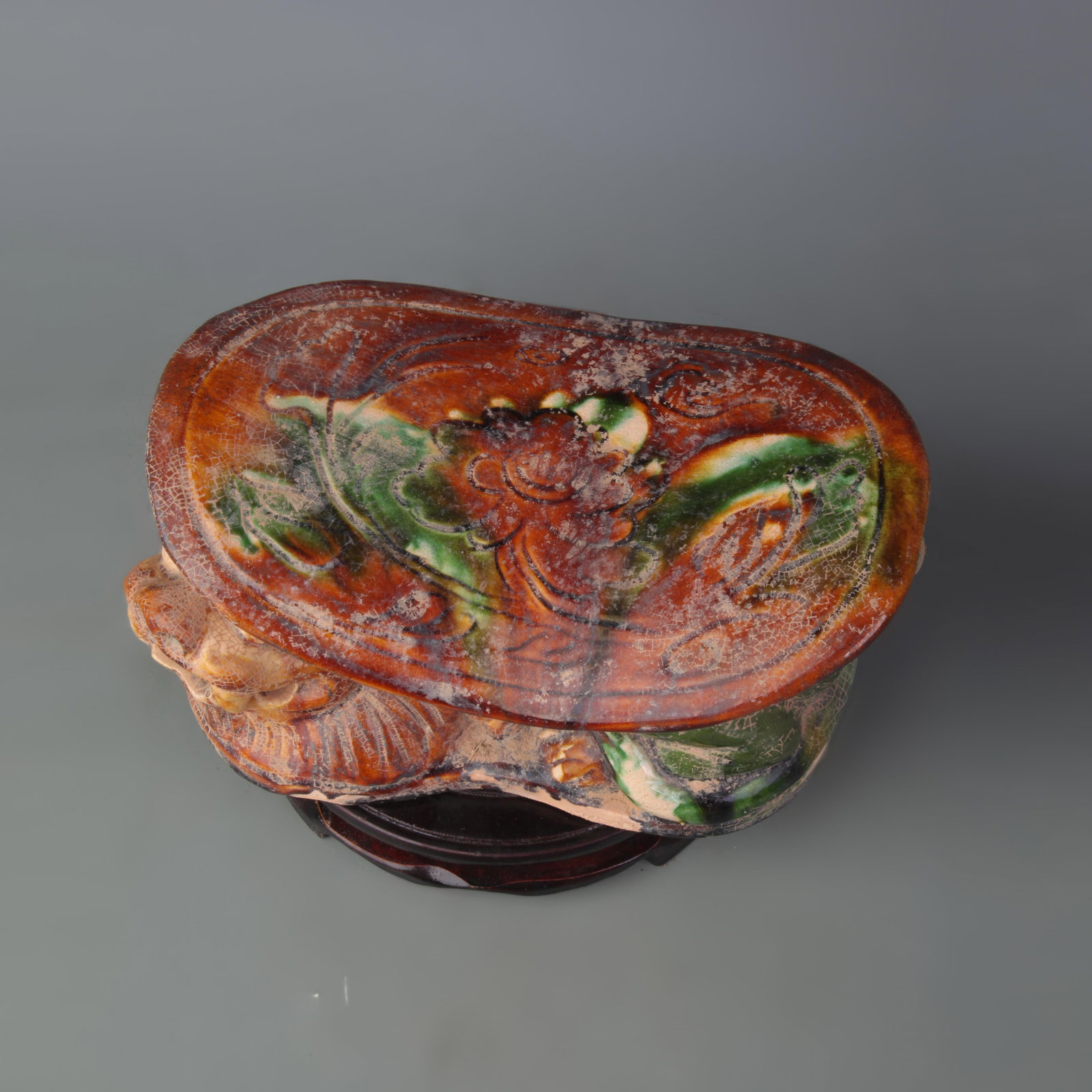A SANCAI TIGER-FORM PILLOW: Tang Dynasty Style; Long: 8.5 inch; High: 4.2 inch; Wooden base for picture and display only.