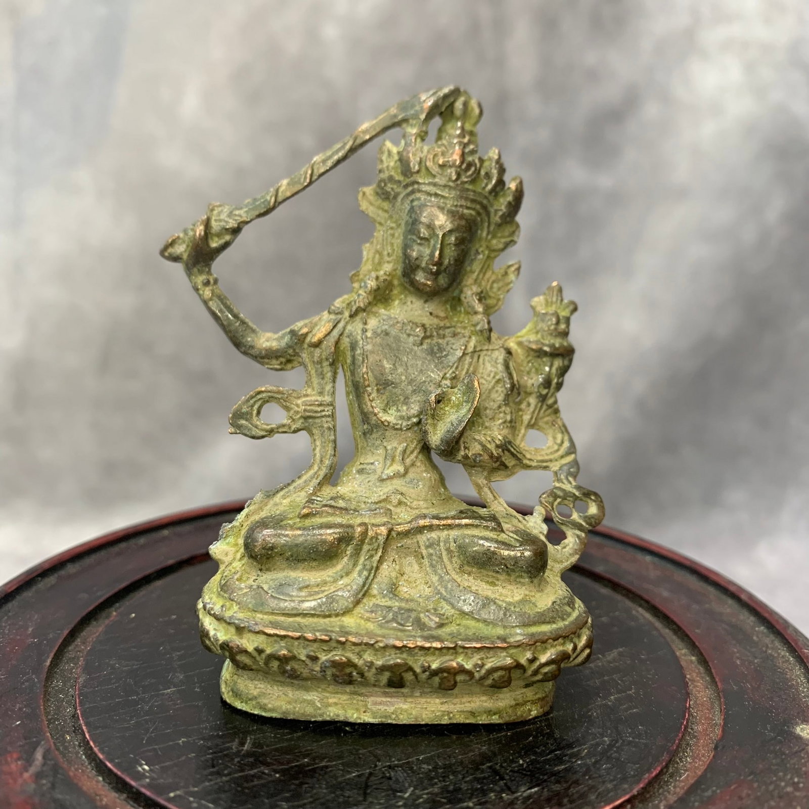 SMALL BRONZE MANJUSRI BUDDHA STATUE: Modern; High: 3.1 inch; Width: 2.3 inch; Long: 1.1 inch. Wooden base for picture and display only.