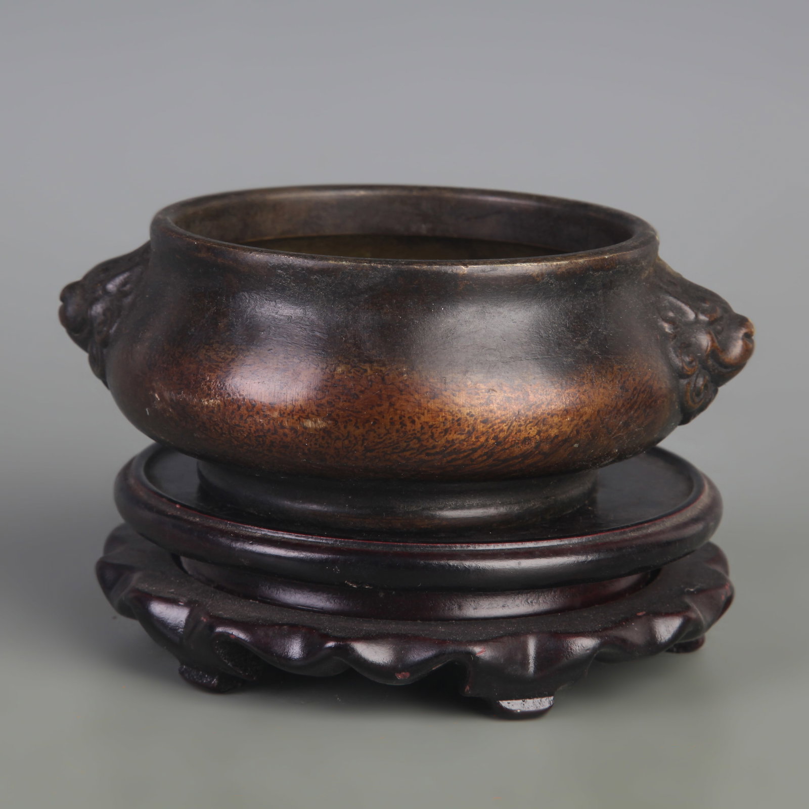 A BRONZE CIRCULAR CENSER WITH ANIMAL-HEAD HANDLES: Ming Dynasty Style; Width: 5.5 inch; High: 2.2 inch; Wooden base for picture and display only.