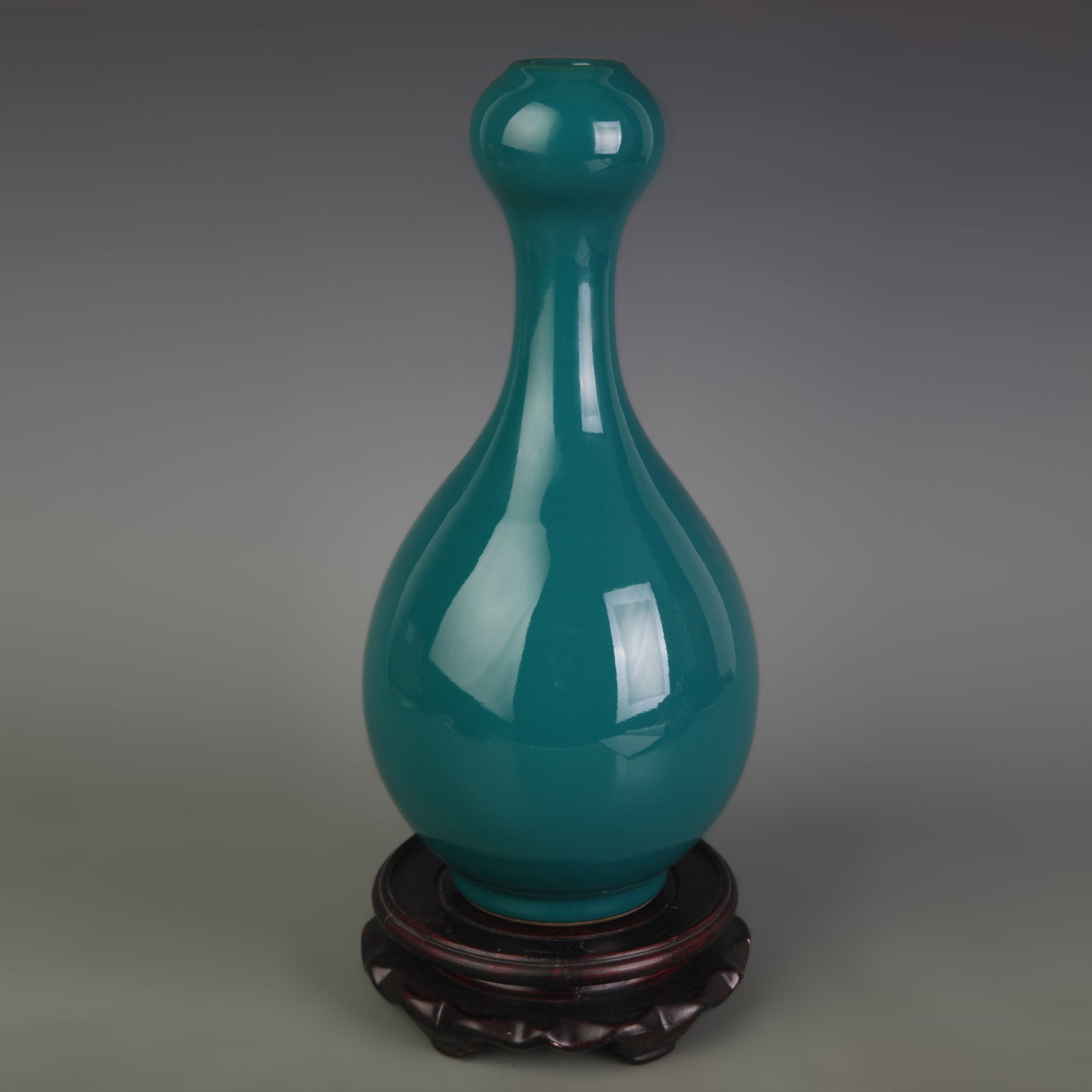 A GREEN GLAZED GARLIC MOUTH PORCELAIN VASE: Qing Dynasty; High: 10.6 inch; Diameter: 2.8 inch; Wooden base for picture and display only.