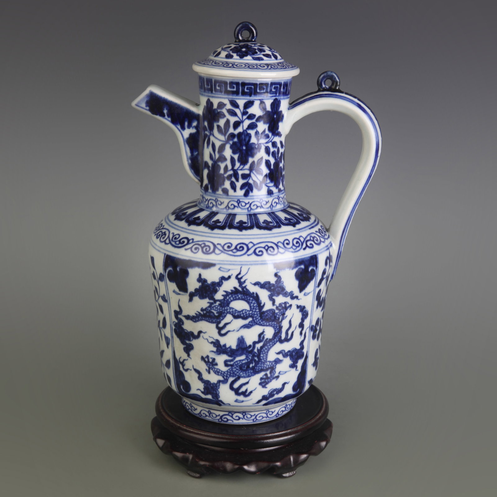 BLUE AND WHITE FLOWER AND DRAGON PATTERN PORCELAIN JUG: Qing Dynasty; Width: 6.5 inch; High: 10.3 inch; Wooden base for picture and display only.