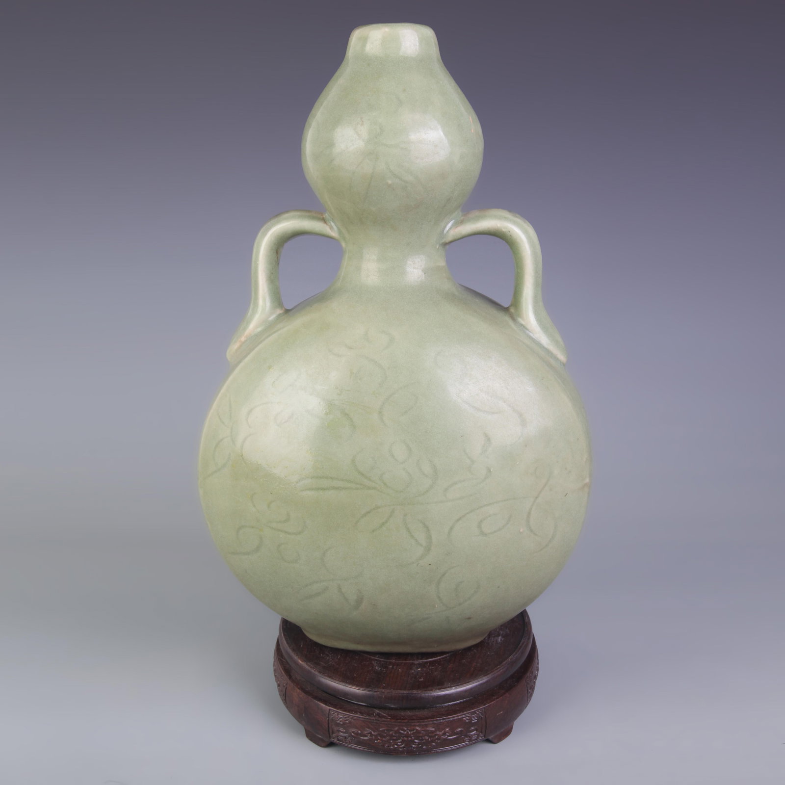 LONGQUAN KILN CARVED DOUBLE-EARED GOURD-SHAPED PORCELAIN VASE: Ming Dynasty Style, High: 14.0; Diameter: 8.5; Wooden base for picture and display only.