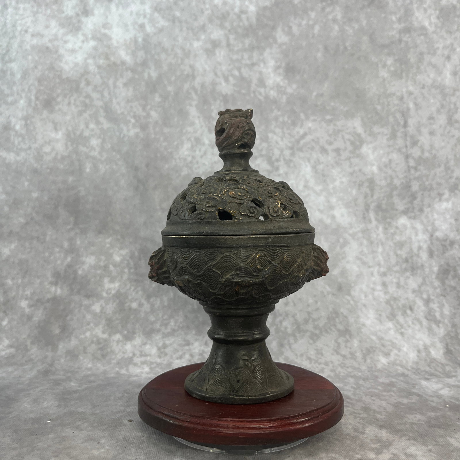 A FINE BRONZE WAVE AND DRAGON MOTIF INCENSE BURNER: Qing Dynasty; Long: 4.8 inch; Width: 4 inch; High: 7.3 inch. Wooden base for picture and display only.