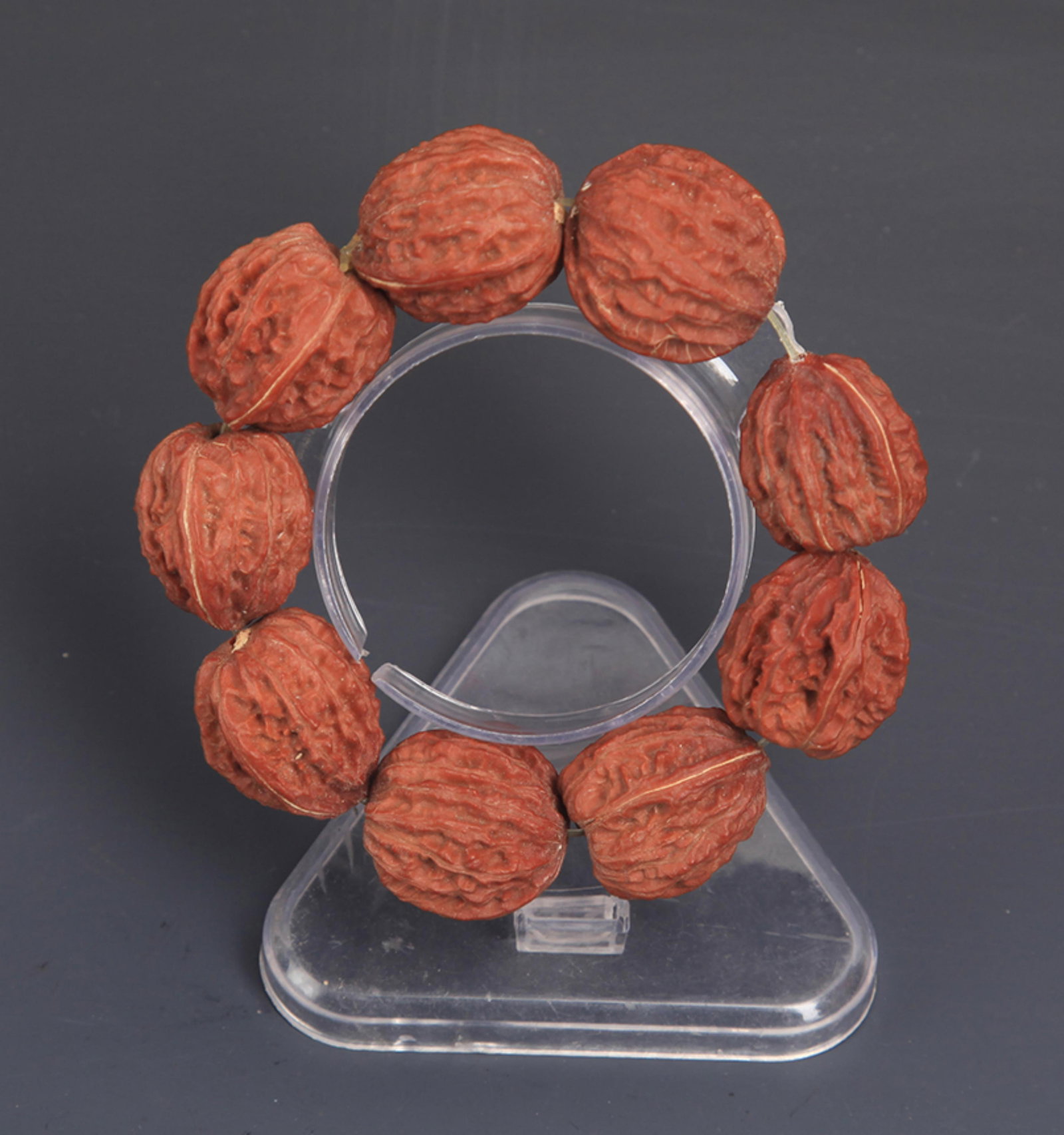 A SMALL CHINESE WALNUT HETAO BRACELETS: Modern; Each Beads:1.25 inch. Wooden base for picture and display only.