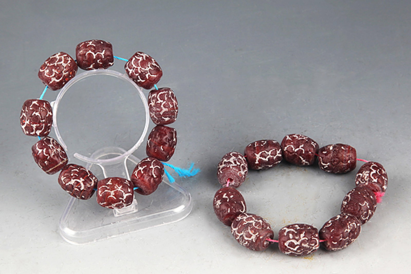 PAIR OF DARK RED COLOR GLASS MADE BRACELETS: Han Dynasty Style; Diameter: 0.75 inch. Wooden base for picture and display only.