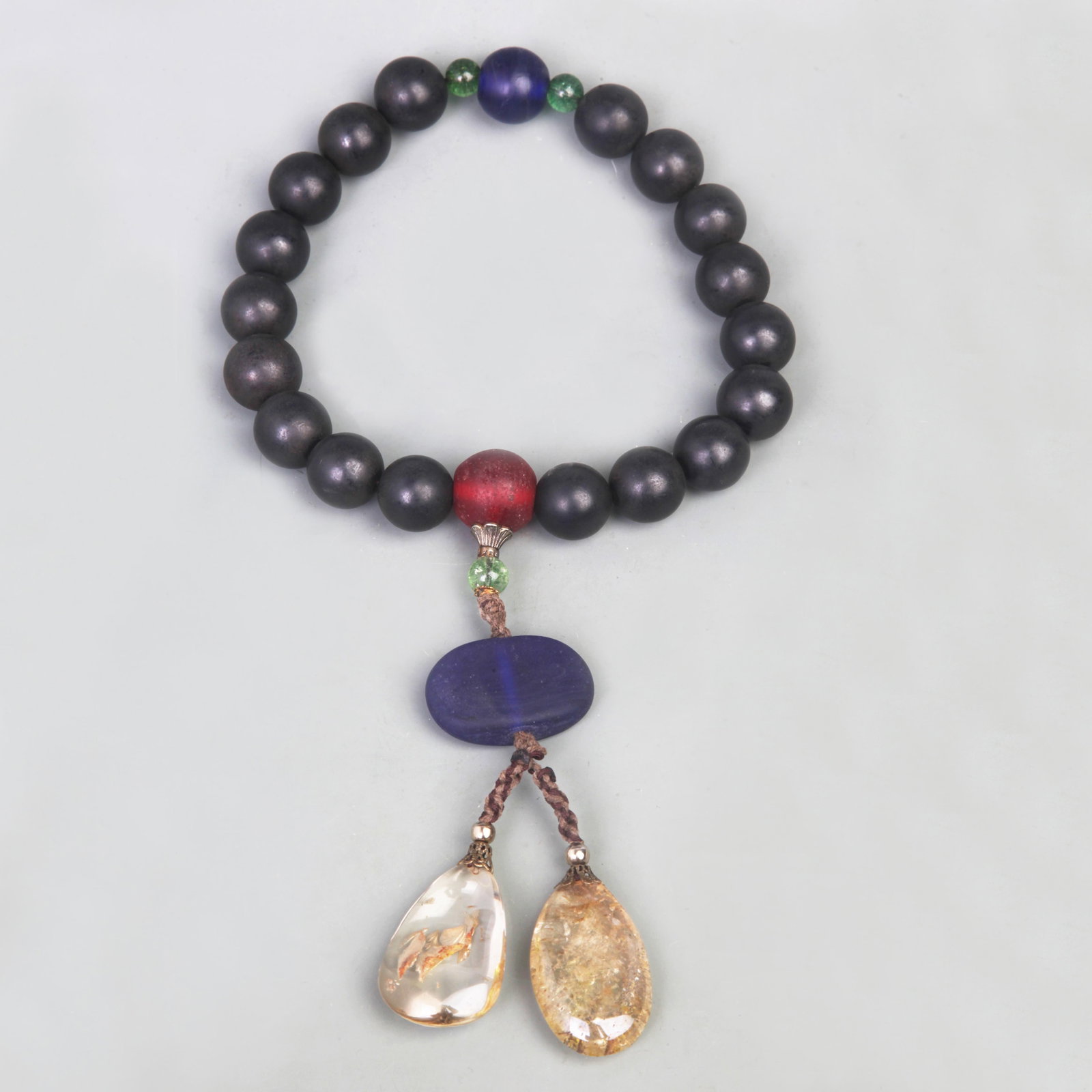 18-PIECE BUDDHIST PRAYER BEADS WITH GEMSTONES, CRYSTAL, AND GLASS: Qing Dynasty; Diameter: 0.7 inch. Wooden base for picture and display only.