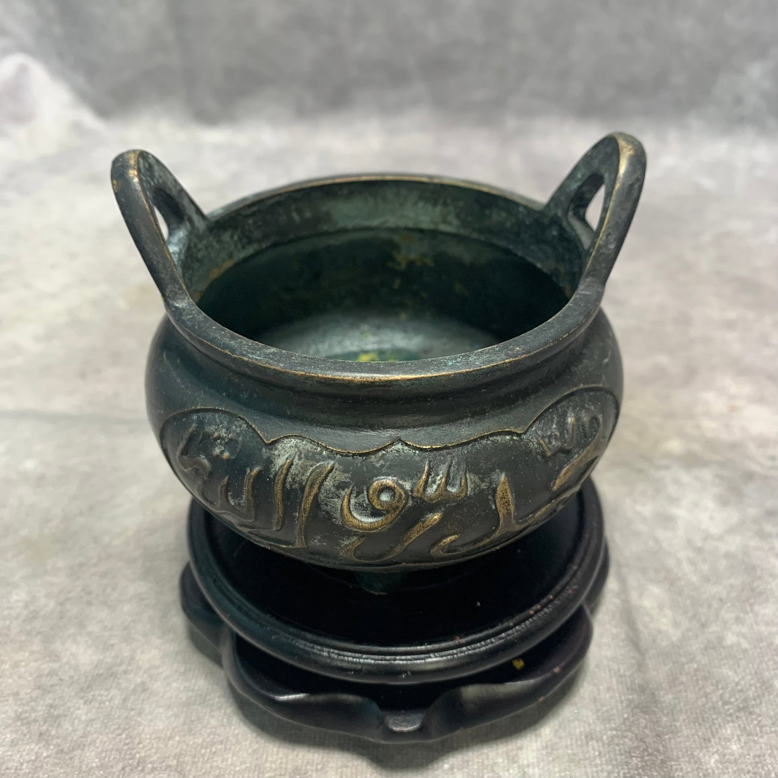 BRONZE TRIPOD CENSER WITH BRIDGE HANDLES AND ARABIC SCRIPT: Ming Dynasty Style; High: 3.4 inch; Diameter: 3.9 inch; Wooden base for picture and display only.