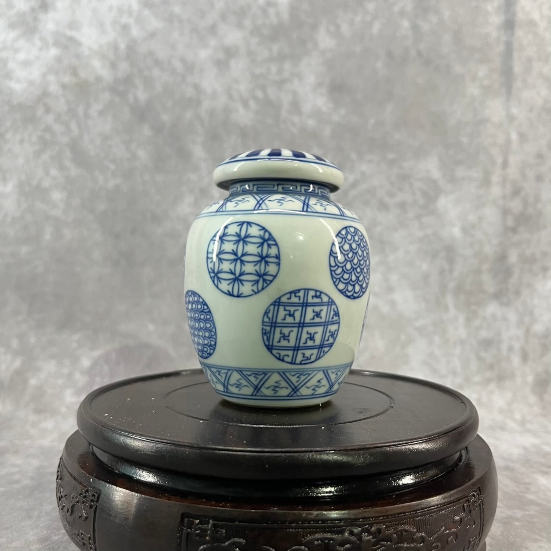 A FINE SMALL BLUE AND WHITE PORCELAIN TEA CADDY: Qing Dynasty; High: 3.93 inch; Diameter: 3 inch. Wooden base for picture and display only.