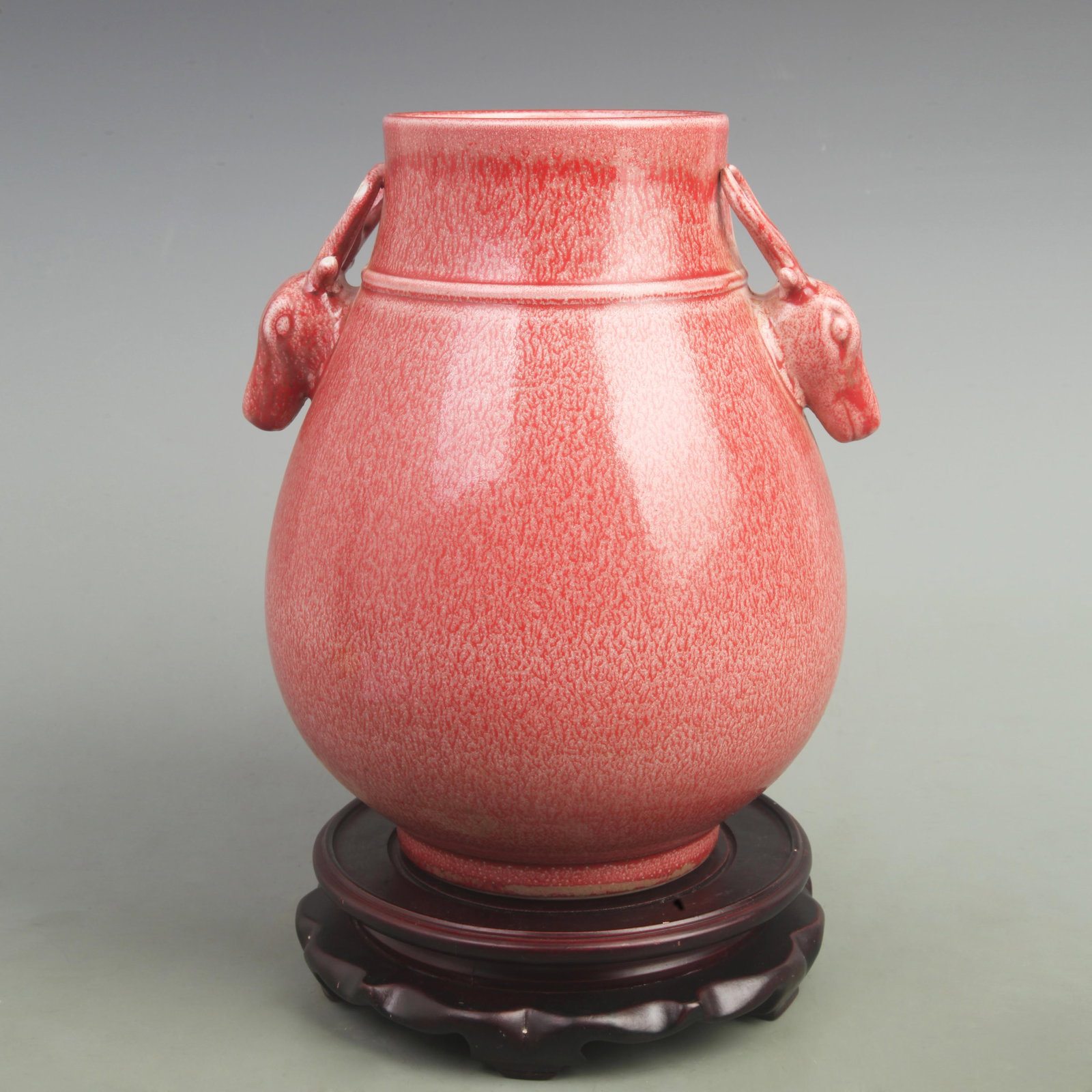 A FINE CINNABAR RED GLAZED DOUBLE DEER HANDLED PORCELAIN VASE: Qing Dynasty Yong Zheng Period; High: 11 inch; Width: 9 inch. Wooden base for picture and display only.