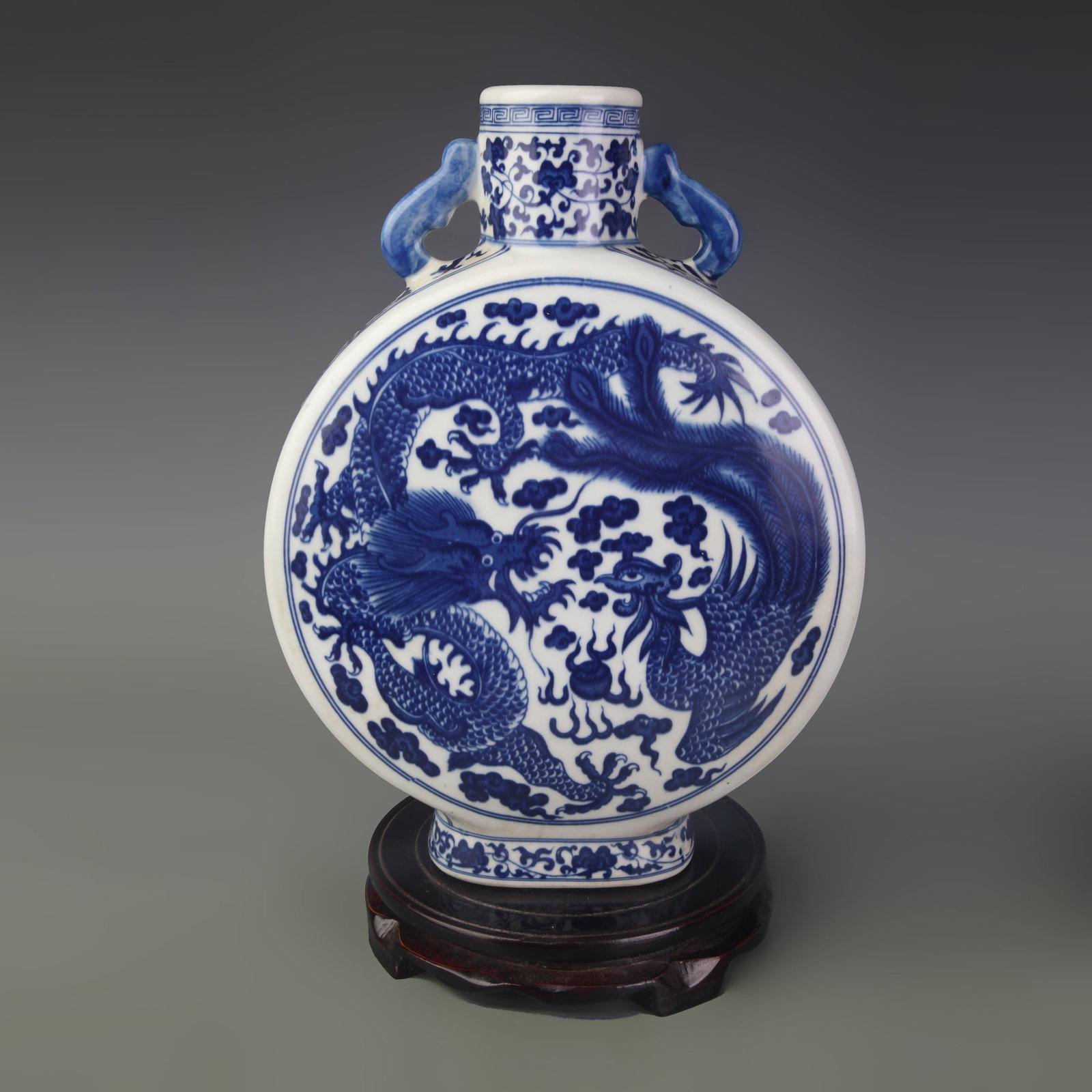 A BLUE AND WHITE PORCELAIN MOON FLASK WITH DRAGON MOTIF: Qing Dynasty; High: 12.2 inch; Diameter: 2.5 inch; Wooden base for picture and display only.