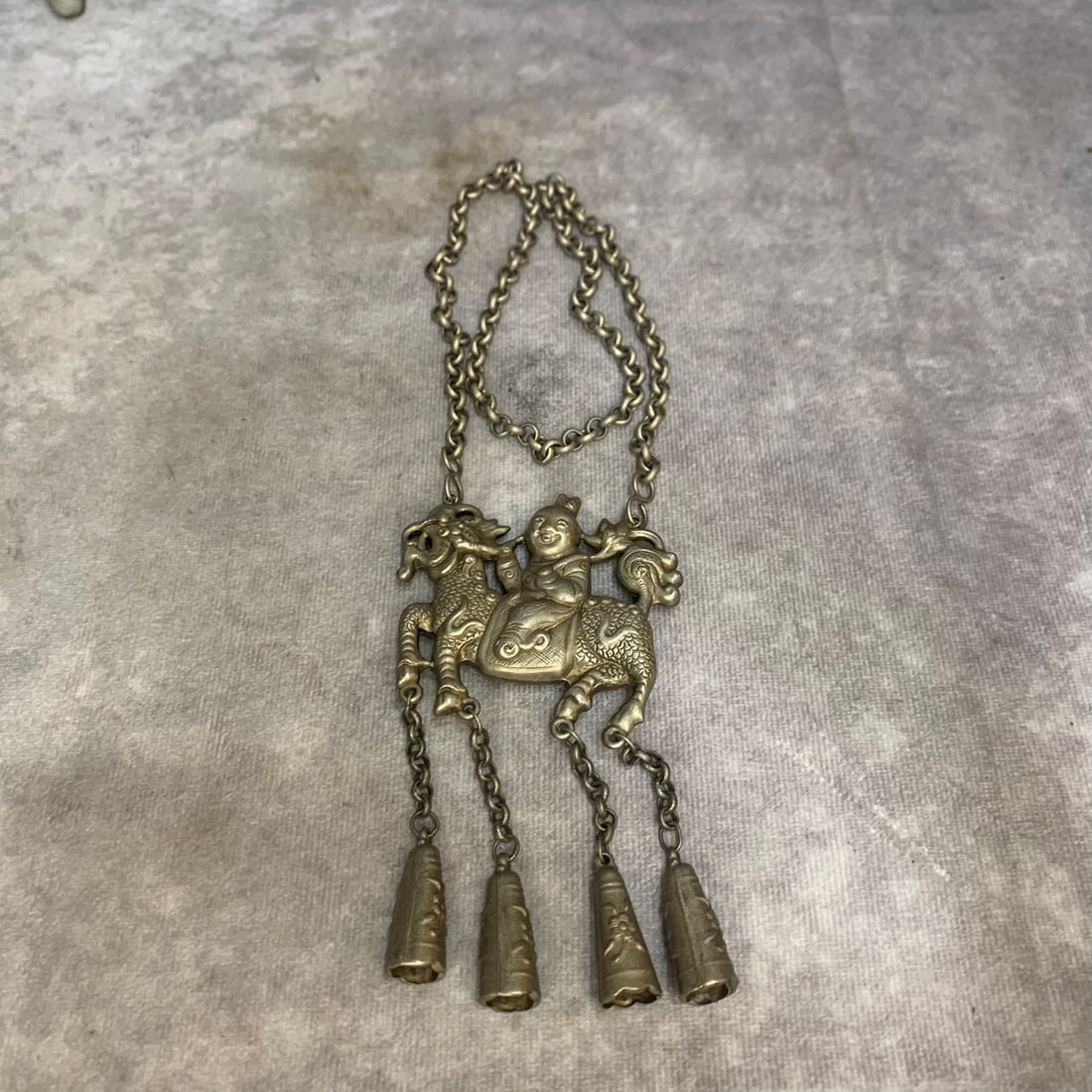 A FINE CHINESE WHITE BRASS "QILIN DELIVERING A SON" (QILIN SONGZI) NECKLACE: Republic Period; High: 14.0 inch; Wooden base for picture and display only.